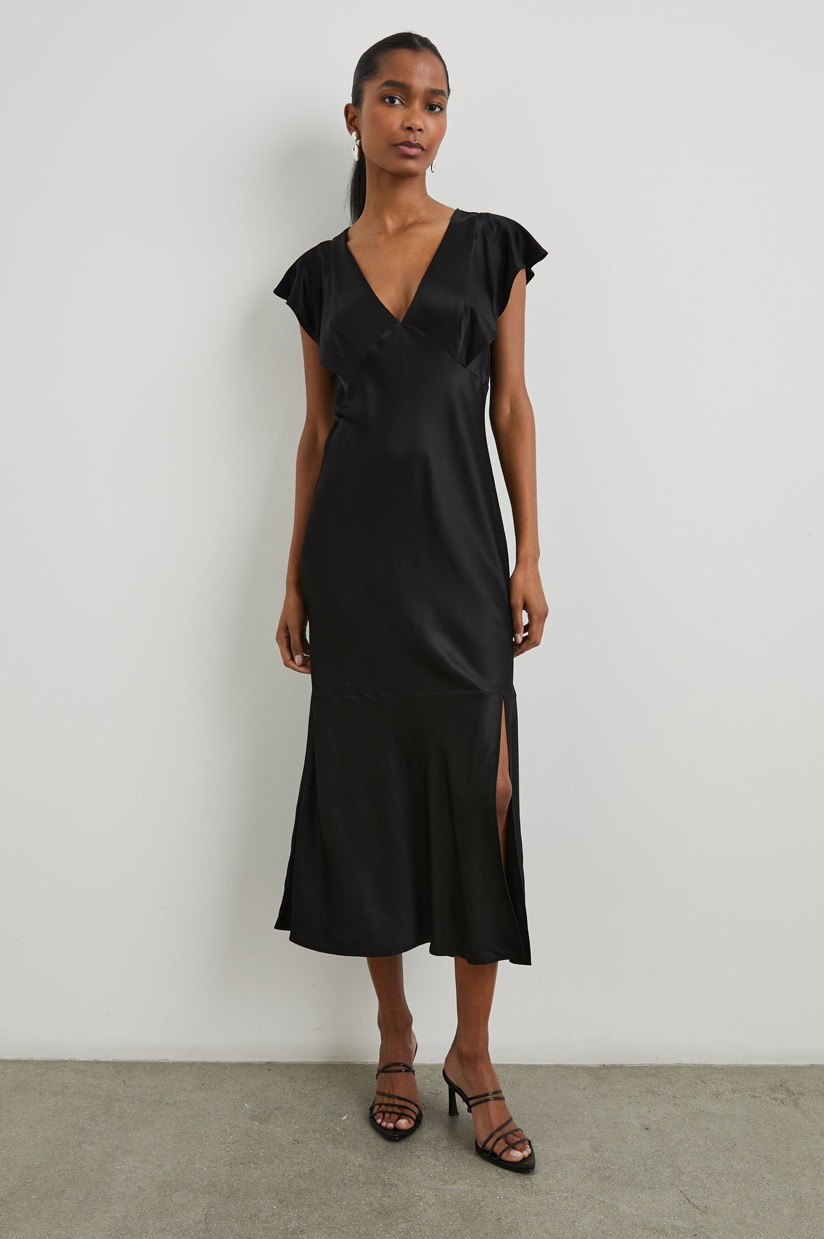 Dina Short-Sleeve Midi Dress with a Deep V Neck, Flutter Sleeves, and a Thigh Side Slit in Black Colorway - Front Full Body View Featured on Model