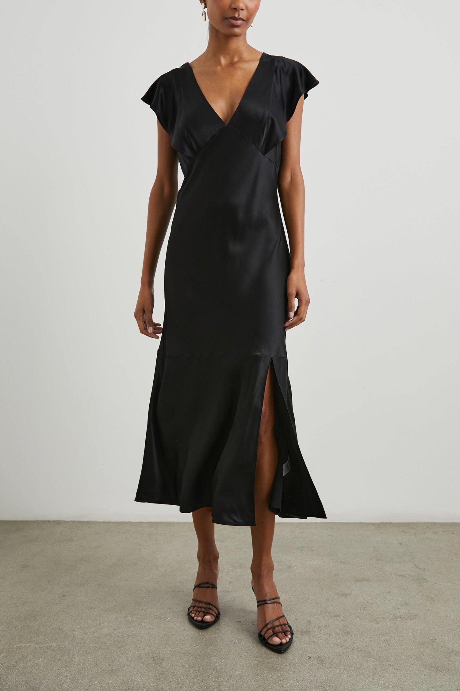 Dina Short-Sleeve Midi Dress with a Deep V Neck, Flutter Sleeves, and a Thigh Side Slit in Black Colorway - Front Full Body View Featured on Model