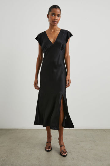 Dina Short-Sleeve Midi Dress with a Deep V Neck, Flutter Sleeves, and a Thigh Side Slit in Black Colorway - Front Full Body View Featured on Model