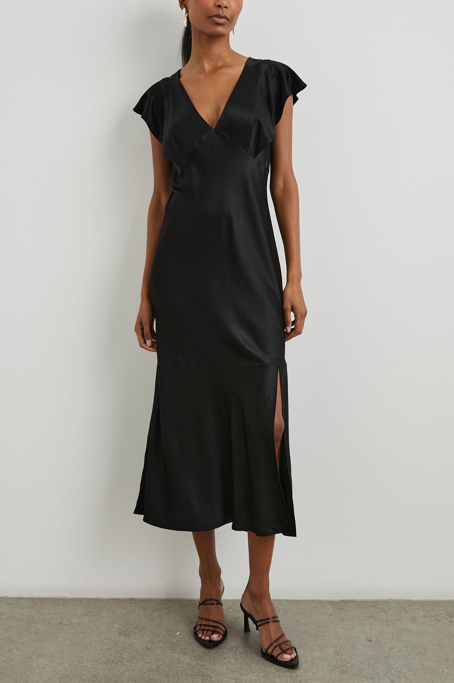 Dina Short-Sleeve Midi Dress with a Deep V Neck, Flutter Sleeves, and a Thigh Side Slit in Black Colorway - Front Full Body View Featured on Model
