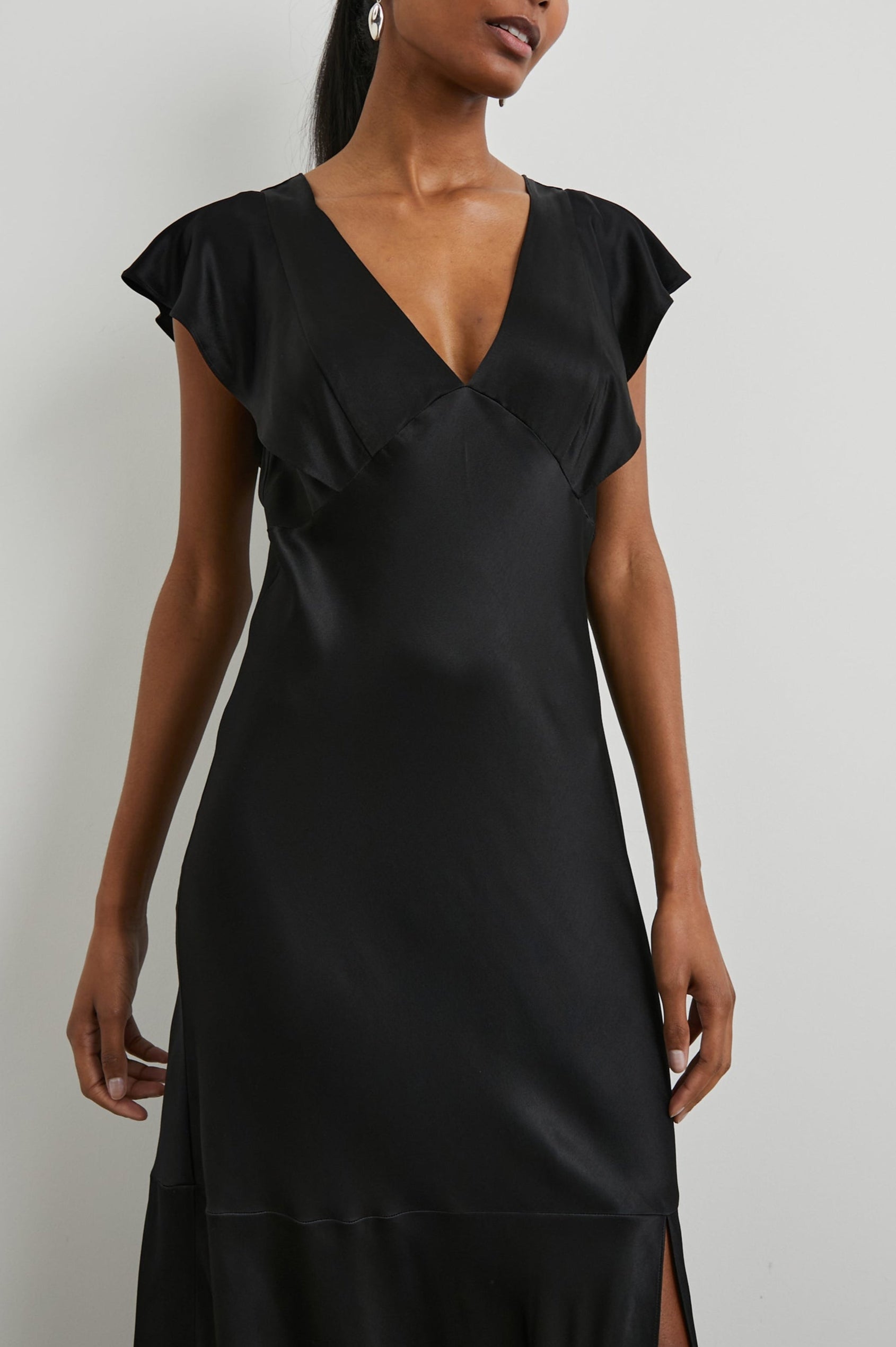Dina Short-Sleeve Midi Dress with a Deep V Neck, Flutter Sleeves, and a Thigh Side Slit in Black Colorway - Front View Featured on Model