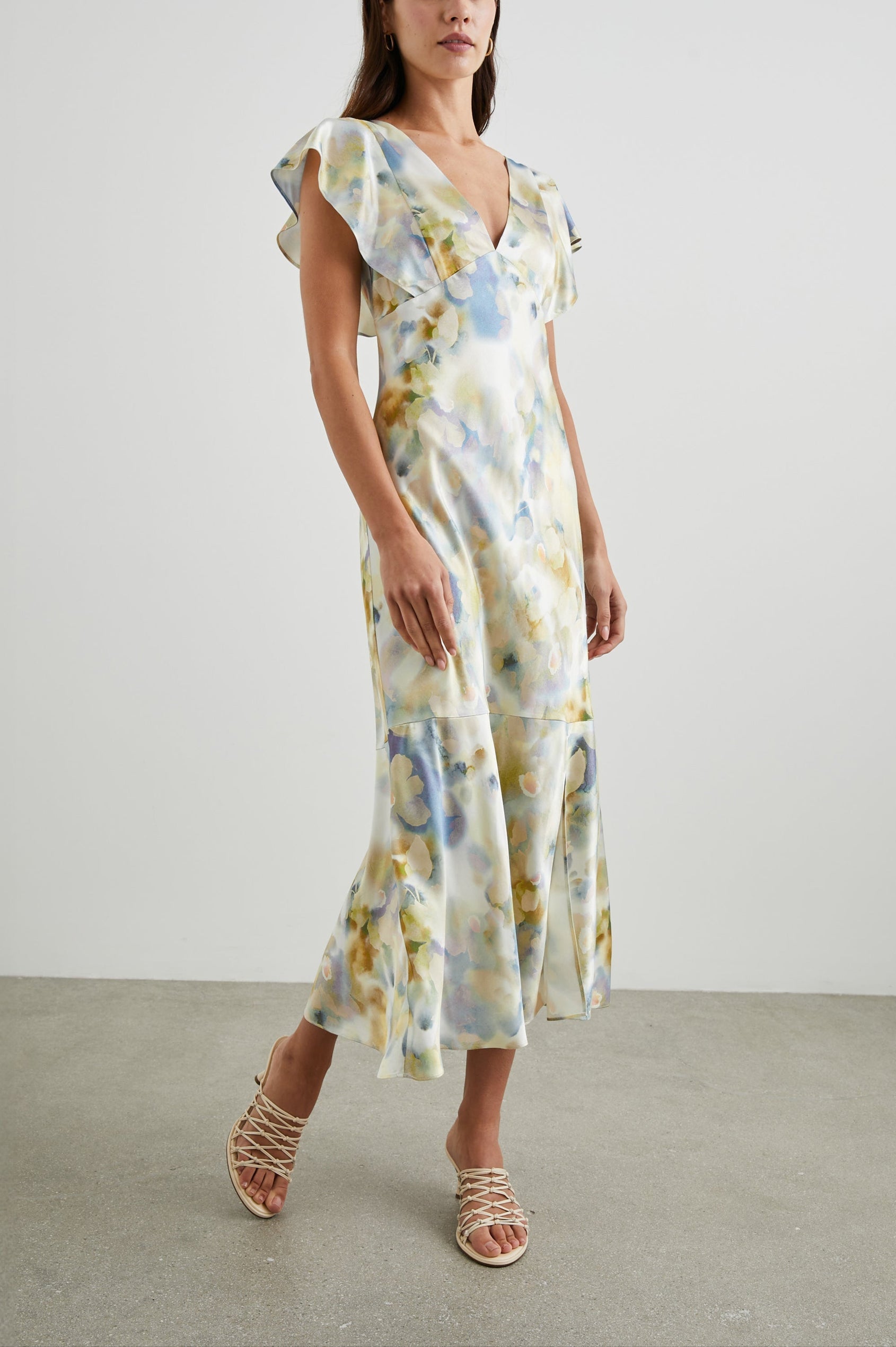 Dina Short-Sleeve Midi Dress with a Deep V Neck, Flutter Sleeves, and a Thigh Side Slit in Diffused Blossom Colorway, Flowers in Gold and Creams on Blue - Front Full Body View Featured on Model