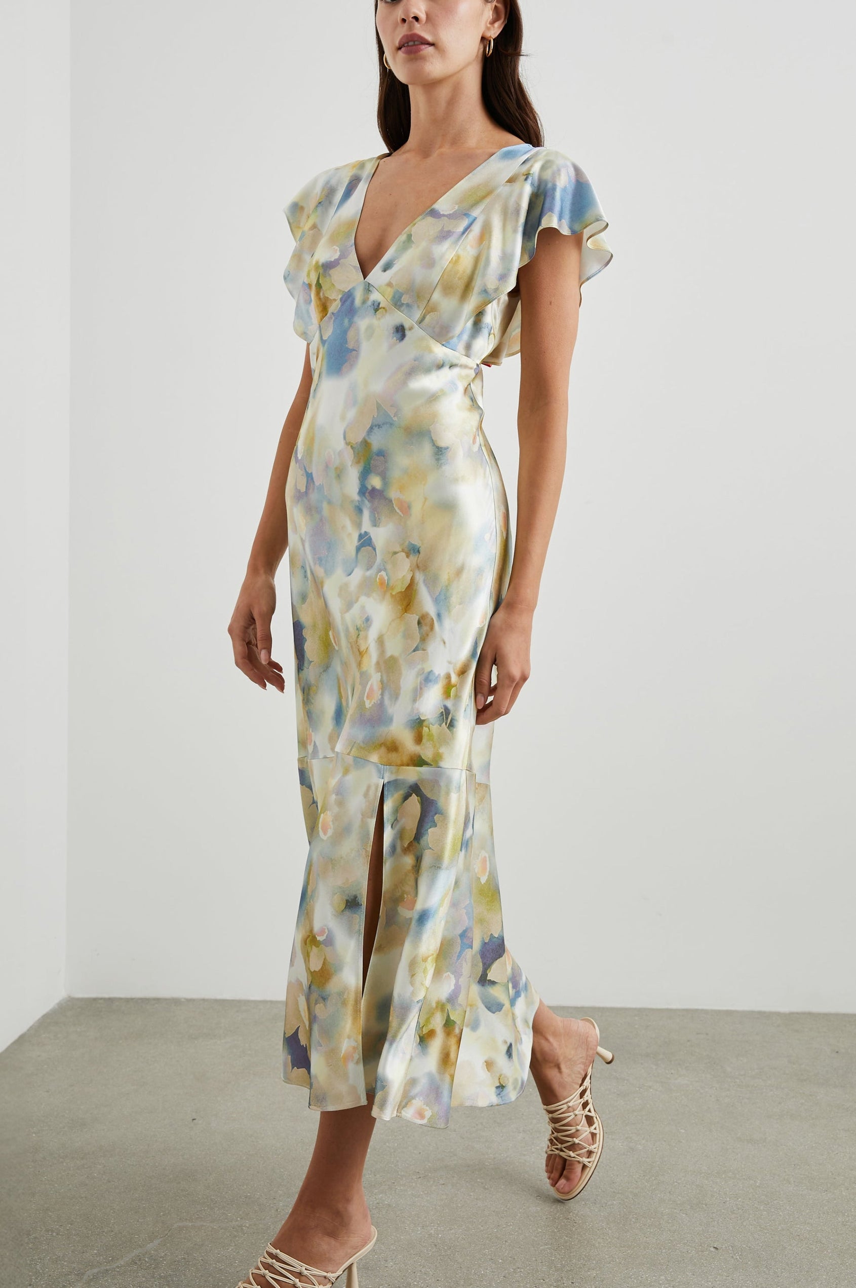 Dina Short-Sleeve Midi Dress with a Deep V Neck, Flutter Sleeves, and a Thigh Side Slit in Diffused Blossom Colorway, Flowers in Gold and Creams on Blue - Front Full Body View Featured on Model