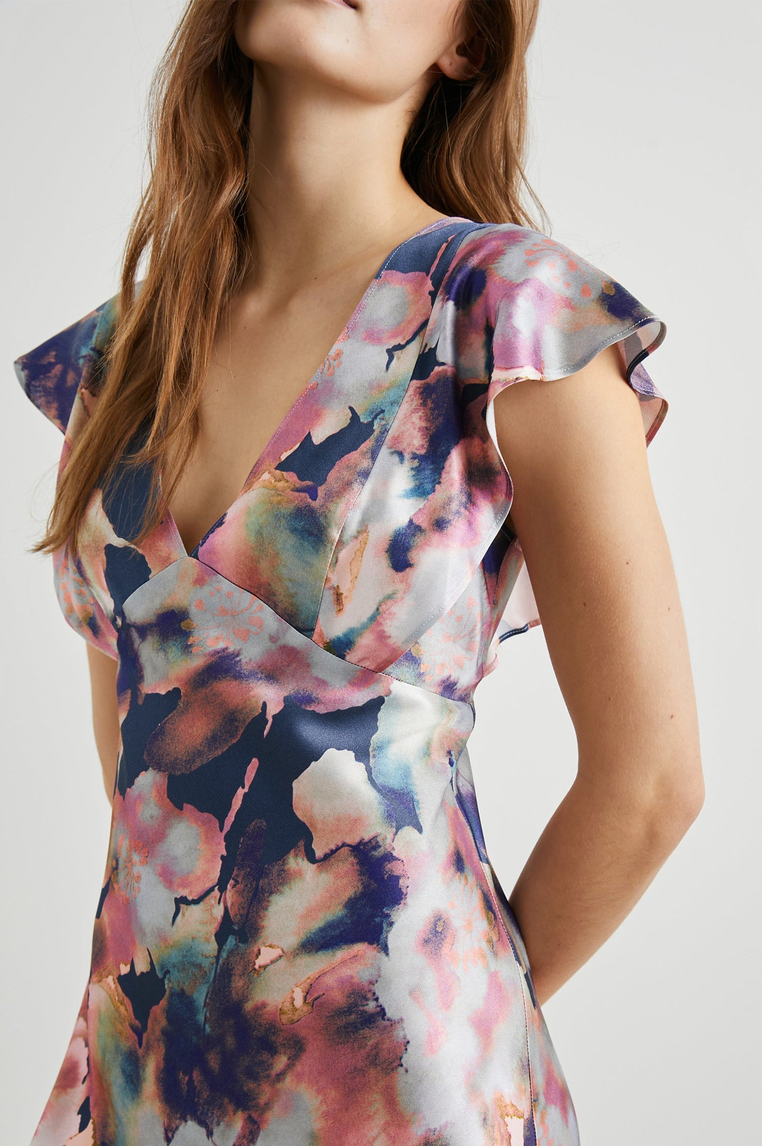 Dina Short-Sleeve Midi Dress with a Deep V Neck, Flutter Sleeves, and a Thigh Side Slit in Midnight Verbena Colorway, Flowers in Pinks, Blues, Oranges and white on Midnight - Front View Featured on Model