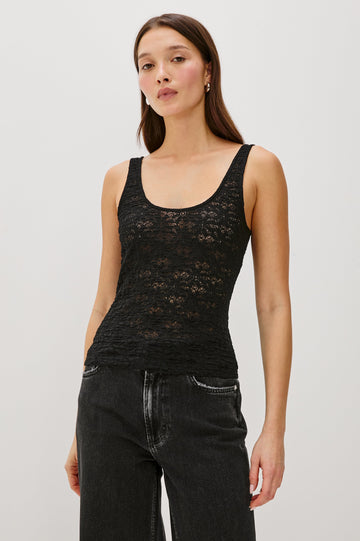 Donya is a sheer, unlined tank top with a scoop neckline in lace fabrication for added texture in Black Lace Colorway - Front View Featured on Model