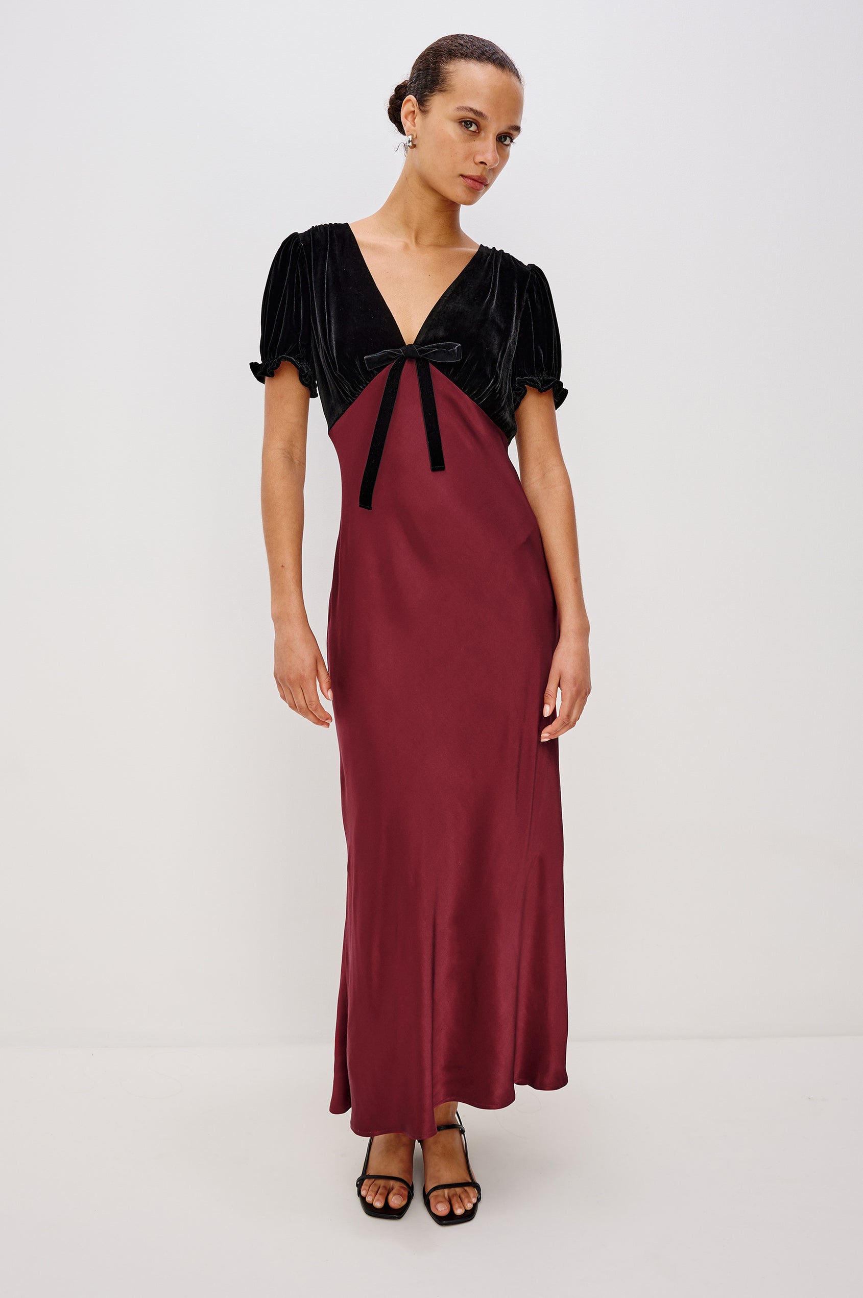 Dory Maxi Dress With Velvet Bodice With V-Neckline and Adjustable Center Bust Ties, Short Puff Sleeves, Satin Back Crepe Skirt, and Back Zipper Closure - Full Body Front View Featured on Model