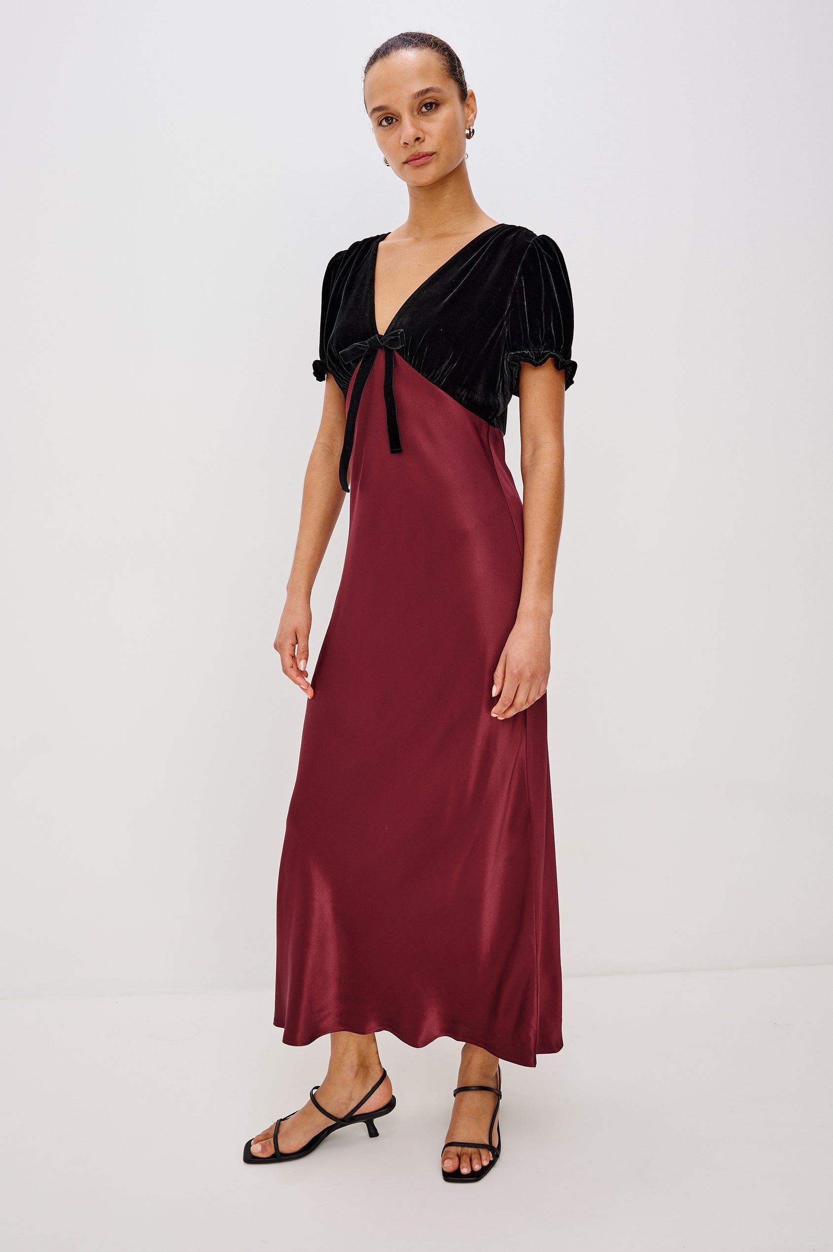 Dory Maxi Dress With Velvet Bodice With V-Neckline and Adjustable Center Bust Ties, Short Puff Sleeves, Satin Back Crepe Skirt, and Back Zipper Closure - Full Body Front View Featured on Model