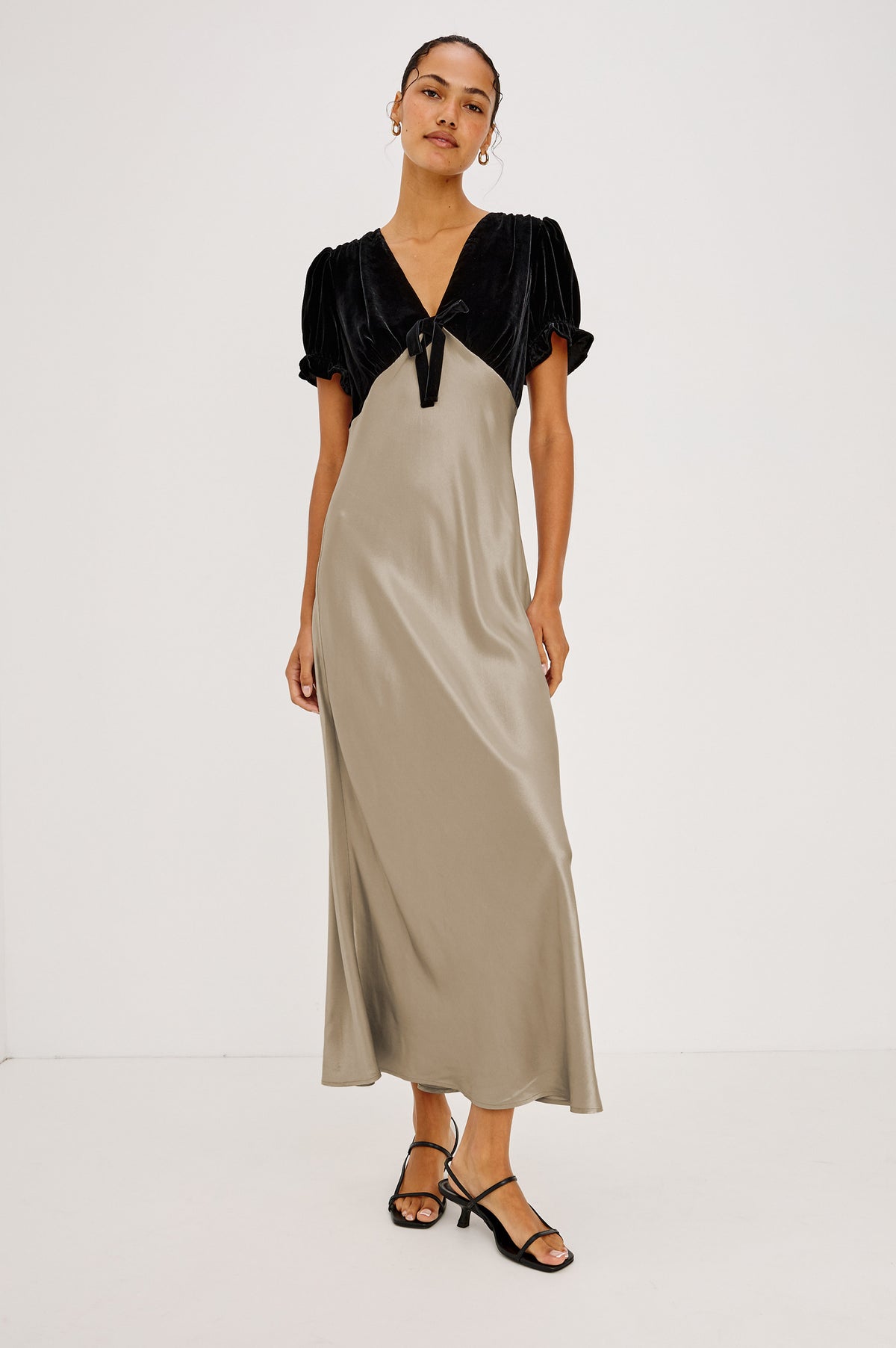 Dory Maxi Dress With V-Neckline and Adjustable Center Bust Ties, Short Puff Sleeves, Satin Back Crepe Skirt, and Back Zipper Closure in Mink Colorway - Front Full Body View Featured on Model.