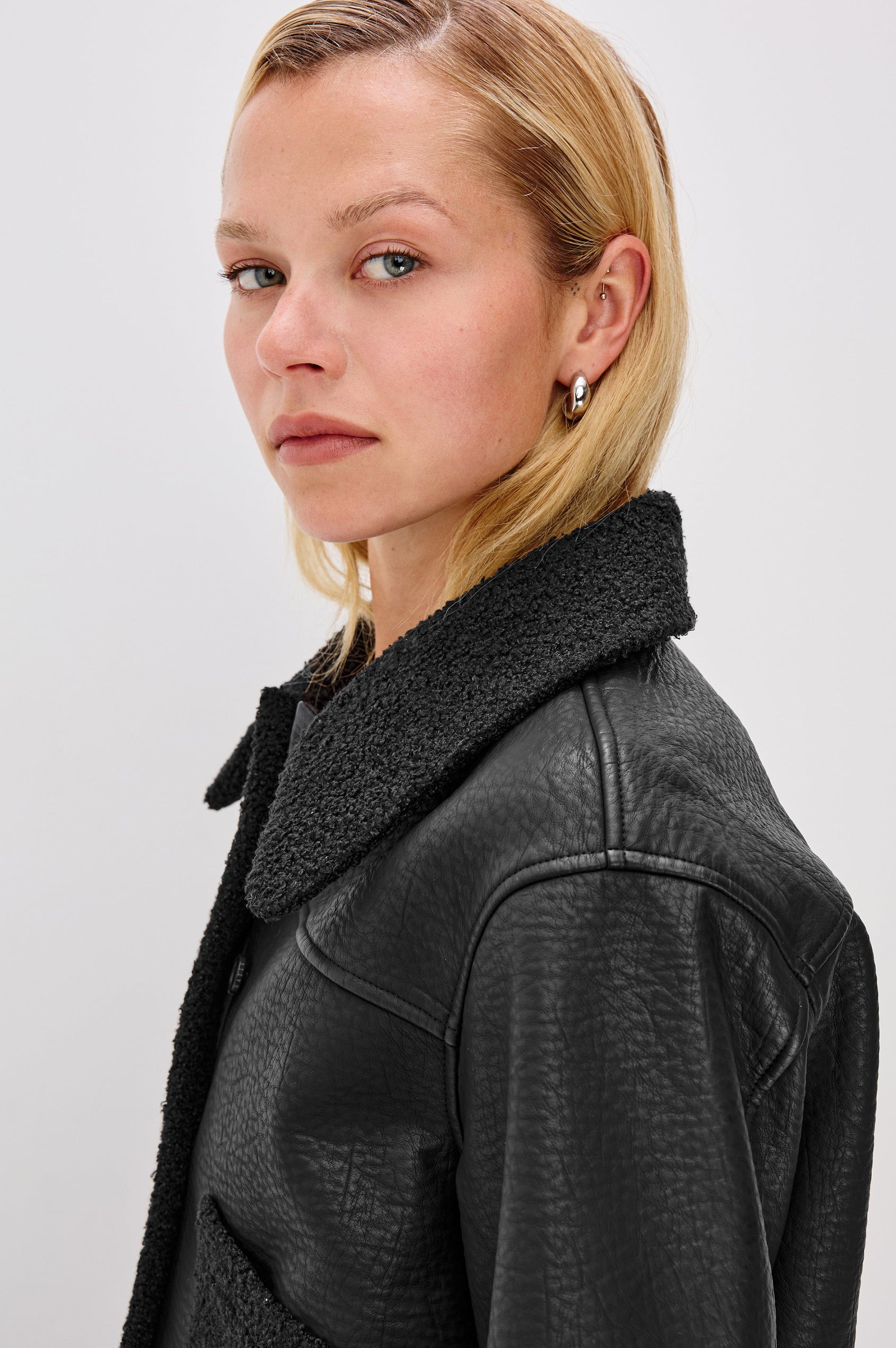 Dria Jacket with Button Closure, Two Front Patch Pockets and Faux Shearling at the Pockets, Cuffs, Collar and Opening in Black Shearling Colorway, Close Up View Featured on Model 