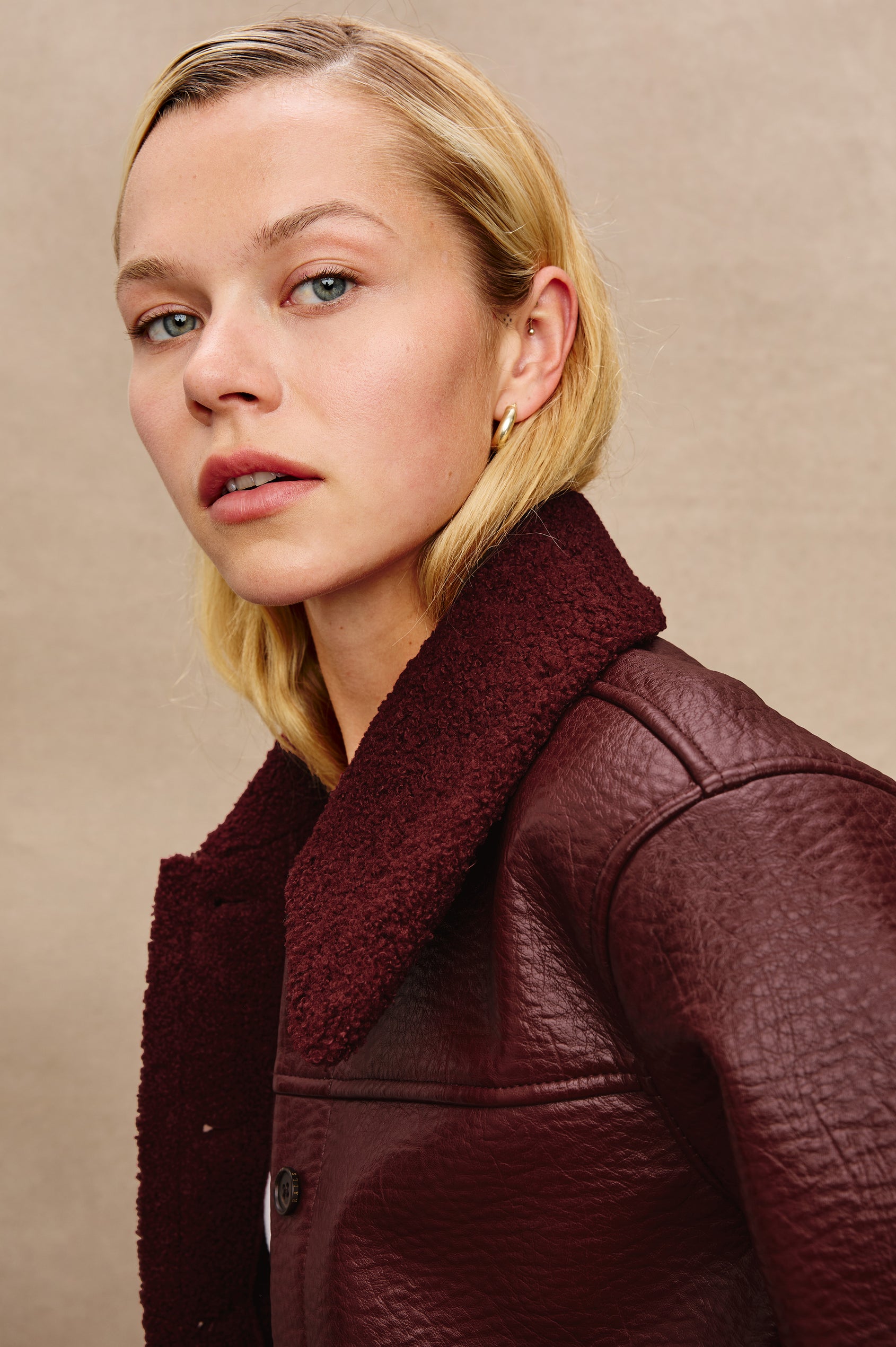 Dria Jacket with Button Closure, Two Front Patch Pockets and Faux Shearling at the Pockets, Cuffs, Collar and Opening in Maroon Shearling Colorway, Close Up View Featured on Model 