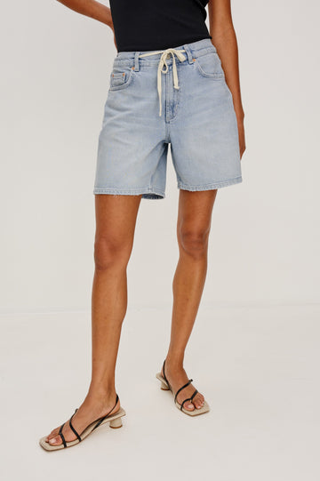 Dume Denim Short, Five Pocket, Zip Fly, Mid-Thigh Length with a White Drawstring Tie Waist in Light Wash Scuba Colorway. Front View Shown on Model.