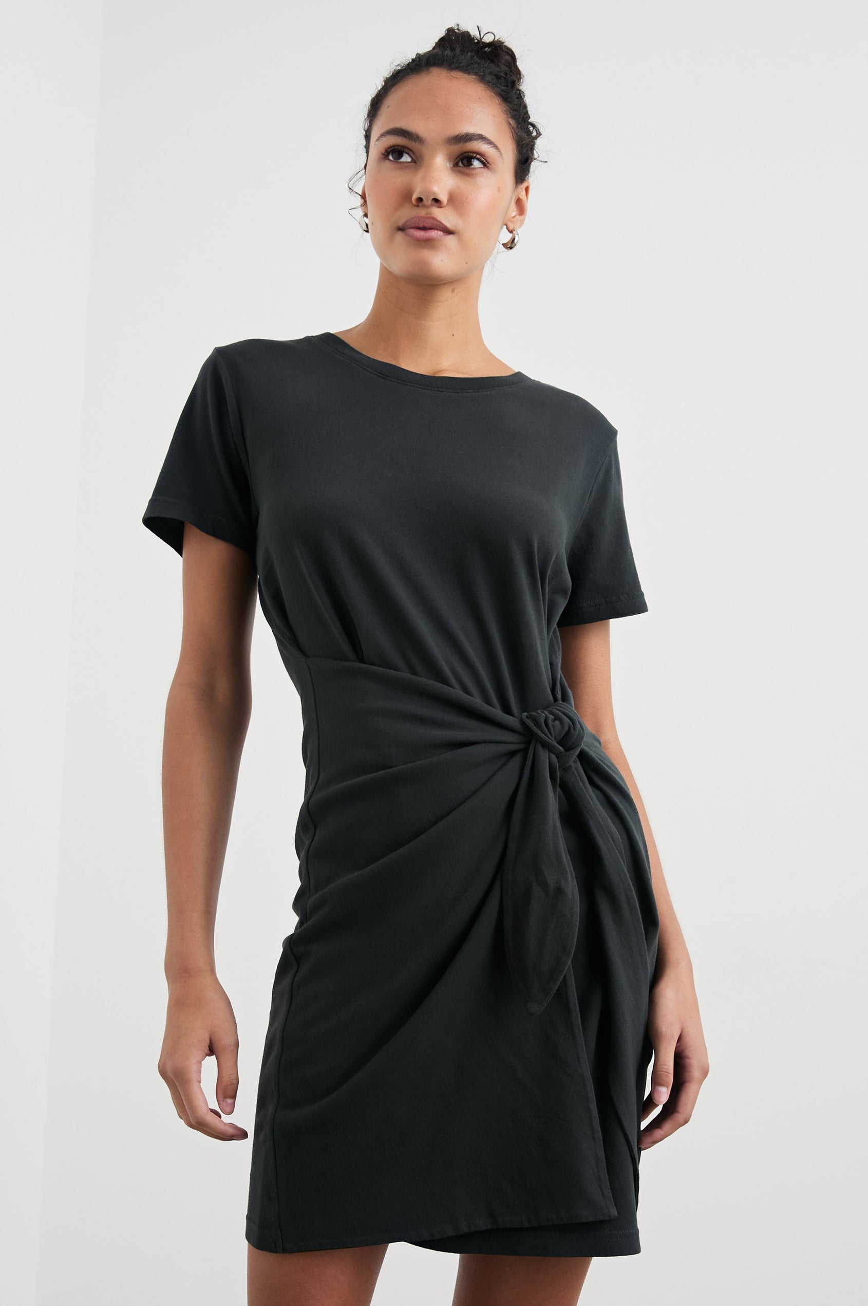 Edie Above-Knee Dress with Short Sleeves, Crew Neckline and Adjustable Wrap Tie At Waist in Vintage Black Colorway - Front View Featured on Model