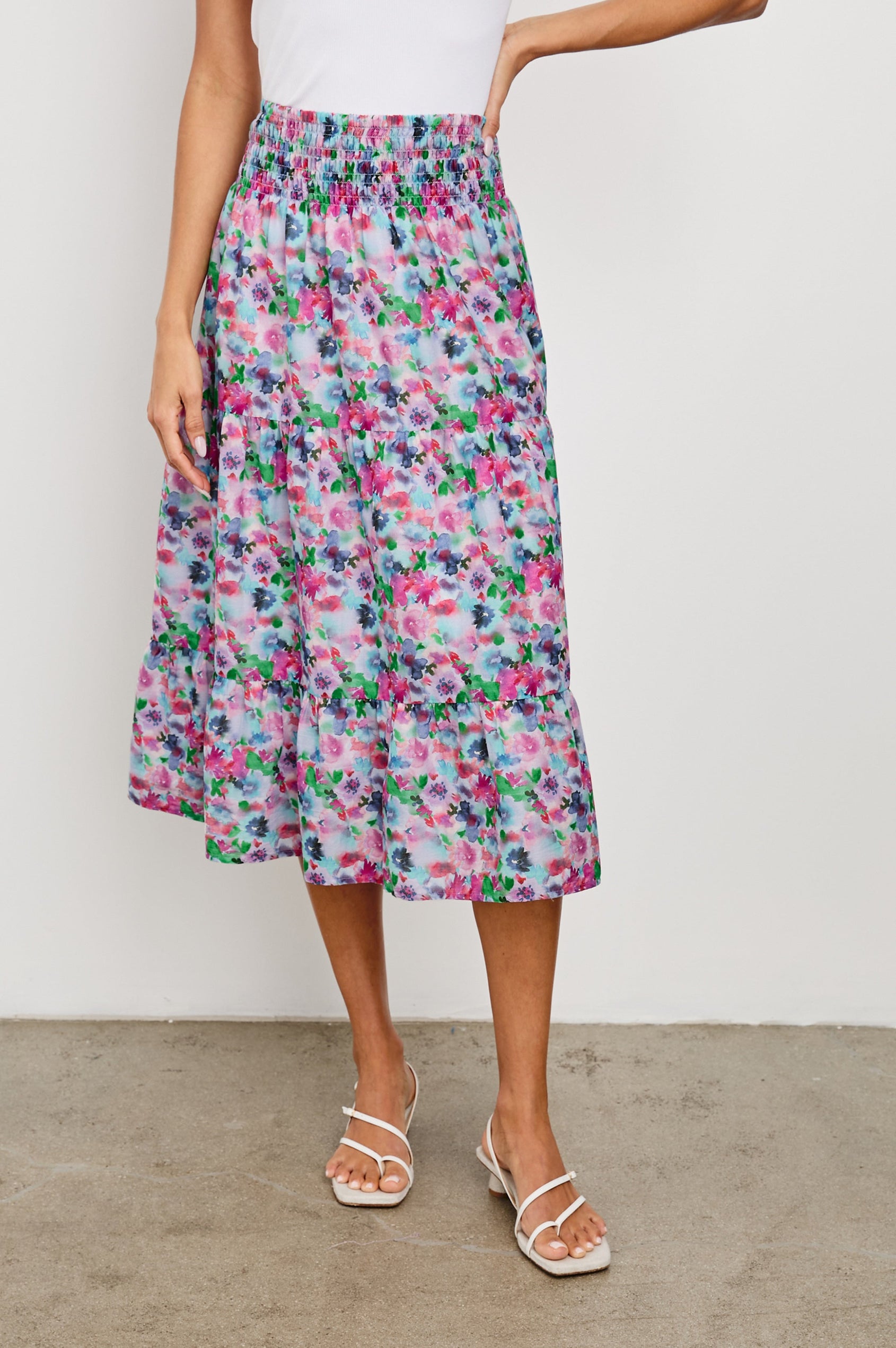Edina Tiered Midi Skirt with Shirred High-Rise Waistline in Spring Floral Colorway, with mostly pinks and purples - Front View Featured on Model