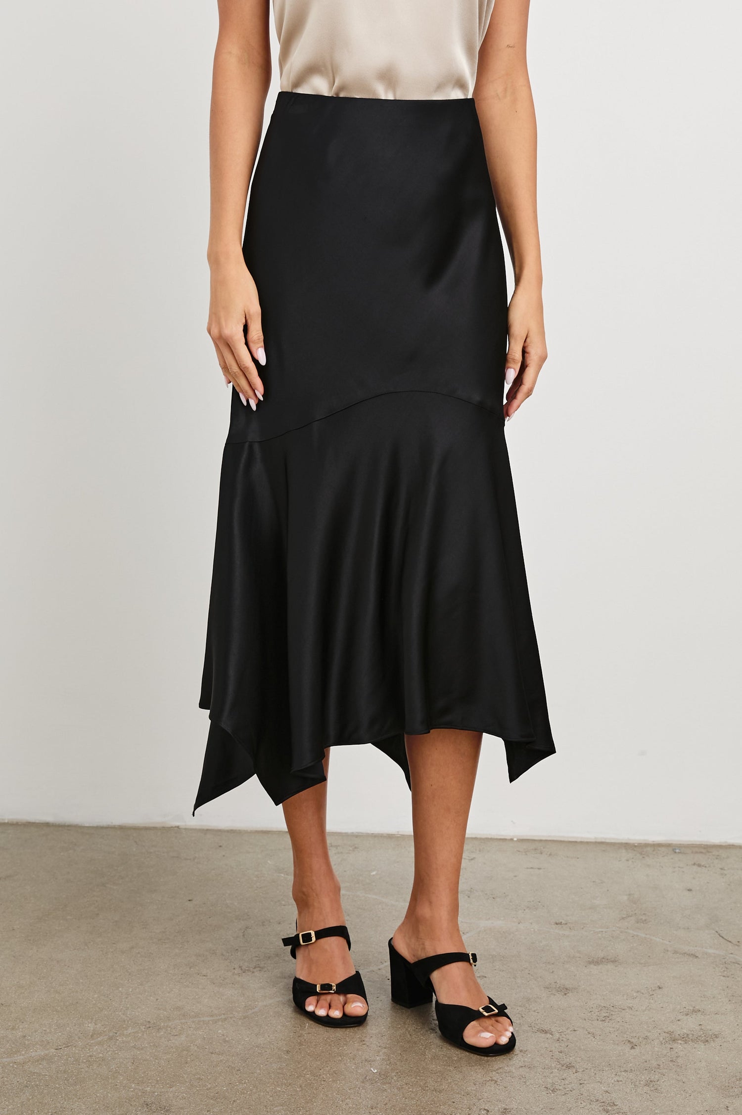 Edwina Midi Skirt with a Handkerchief Hem in Black Colorway - Front View Featured on Model
