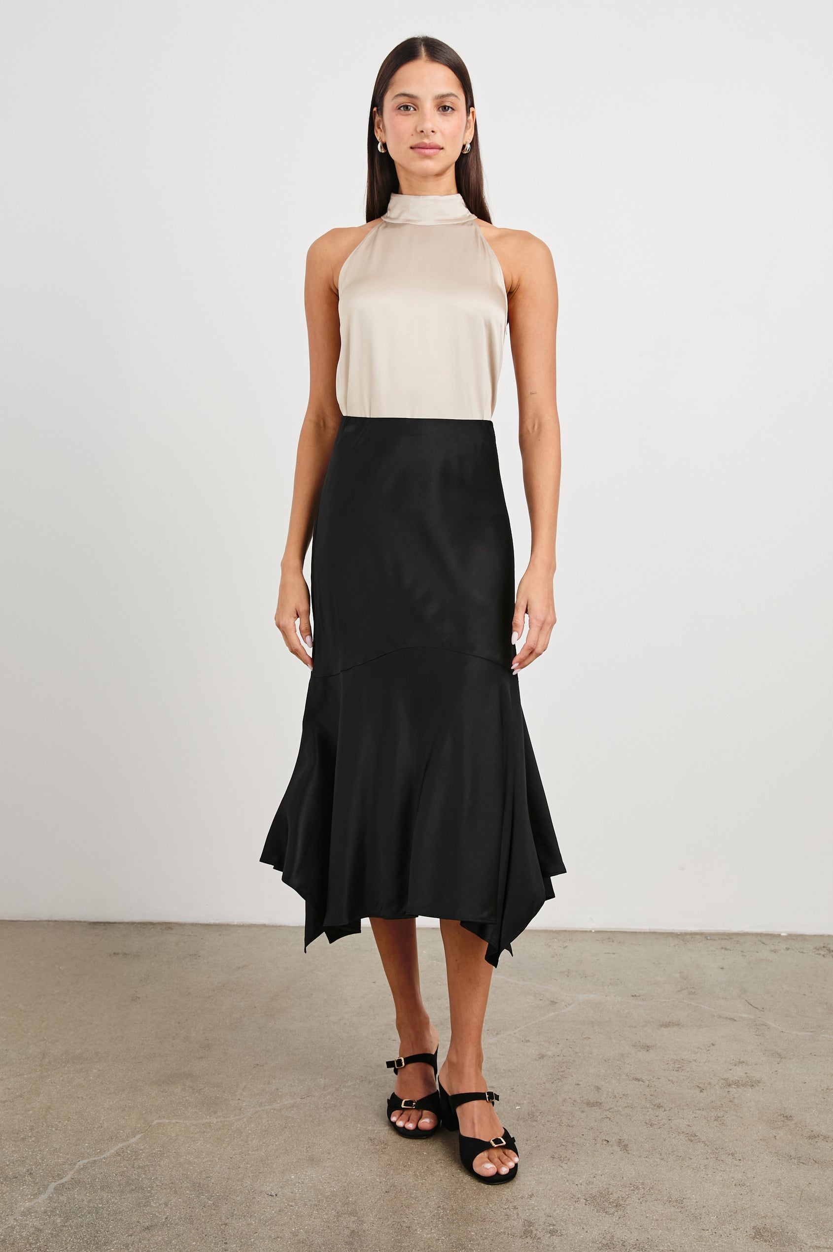 Edwina Midi Skirt with a Handkerchief Hem in Black Colorway - Front Full Body View Featured on Model