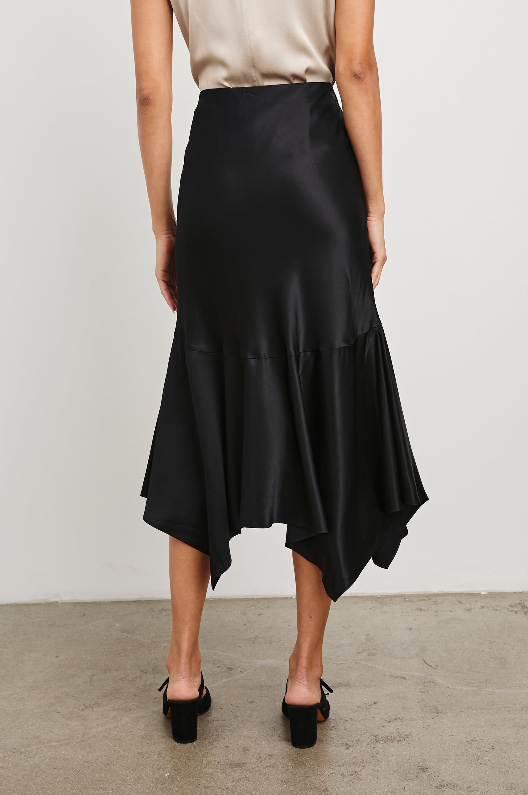 Edwina Midi Skirt with a Handkerchief Hem in Black Colorway - Back View Featured on Model