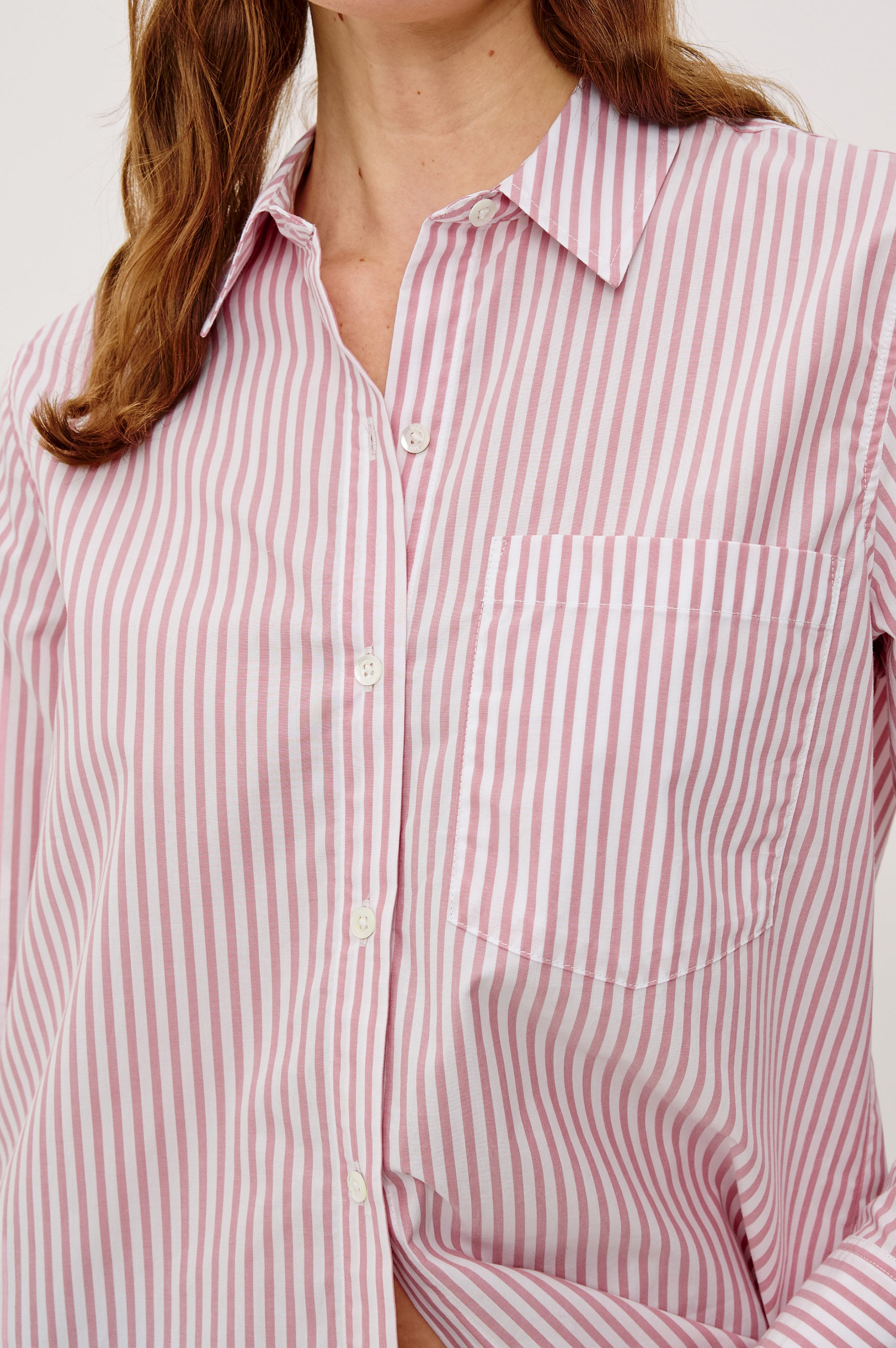 Elsa Button-Up Shirt in Cotton Poplin With Relaxed Oversized Fit Classic Chest Pocket Long Sleeves and Curved Hem in Rose Stripe Colorway - Upper Body Close Up View Featured on Model