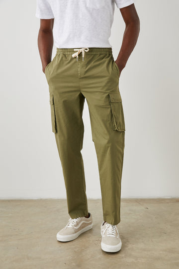 Emmerson Pants with a Drawstring Waist, Two Front Pockets, Two Side Flap Pockets and Two Back Welt Pockets in Olive Colorway - Front View Featured on Model