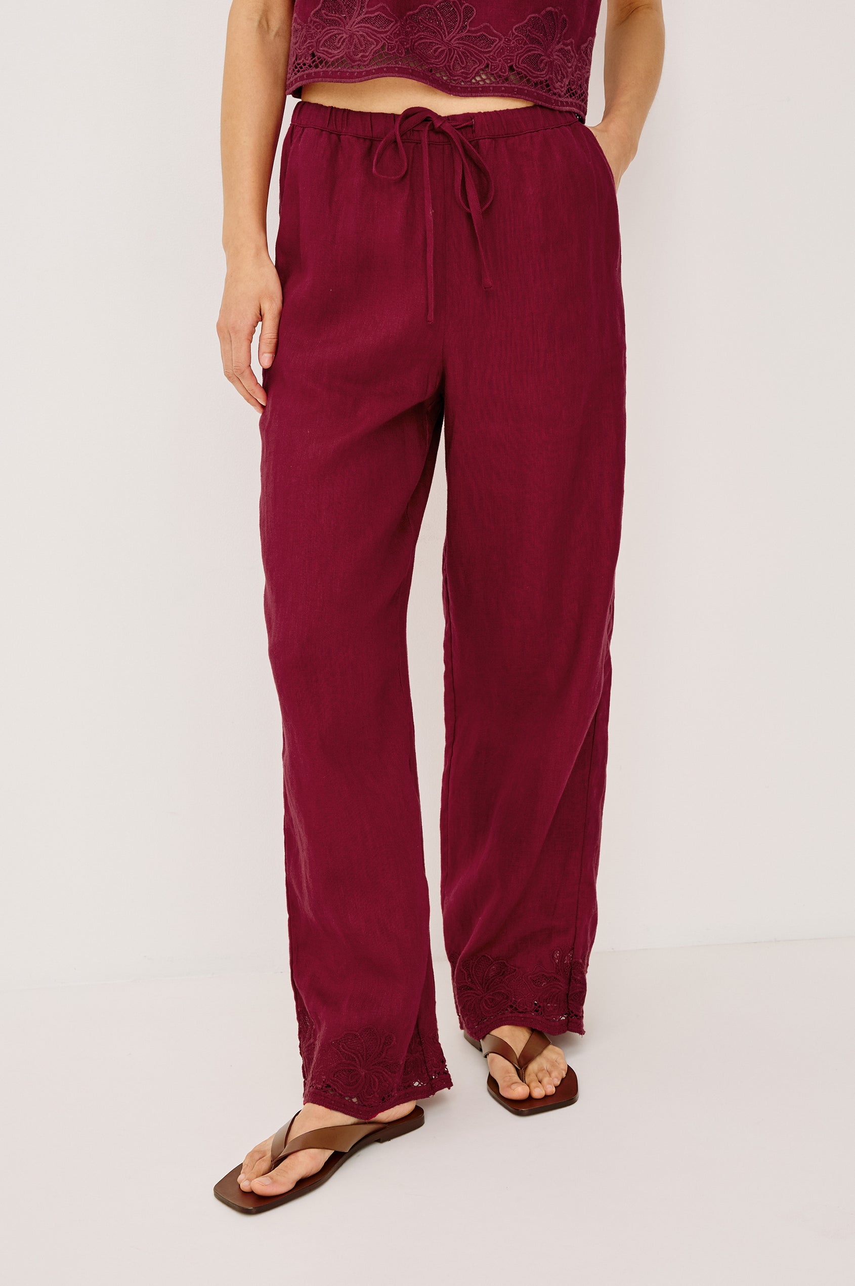 Emmie Straight Leg Pant in Linen With Adjustable Drawstring Waist Ties in Hibiscus Embroidery Colorway — Lower Body Front View Featured on Model