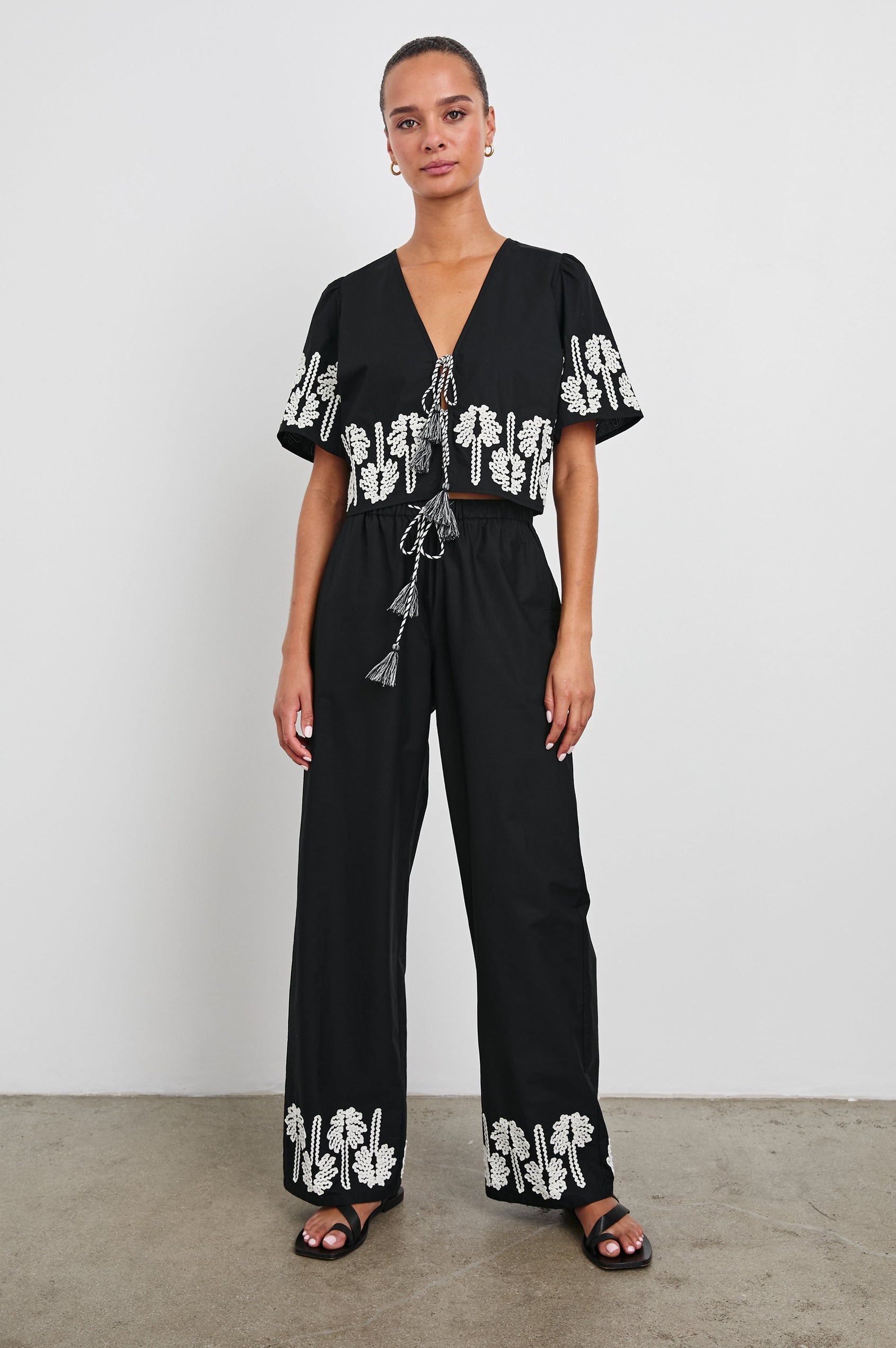 Emmie Pants with a Drawstring Waist and Two Front Pockets in Black Ivory Palm Trees Colorway, with white palm trees at the cuffs  - Front Full Body View Featured on Model
