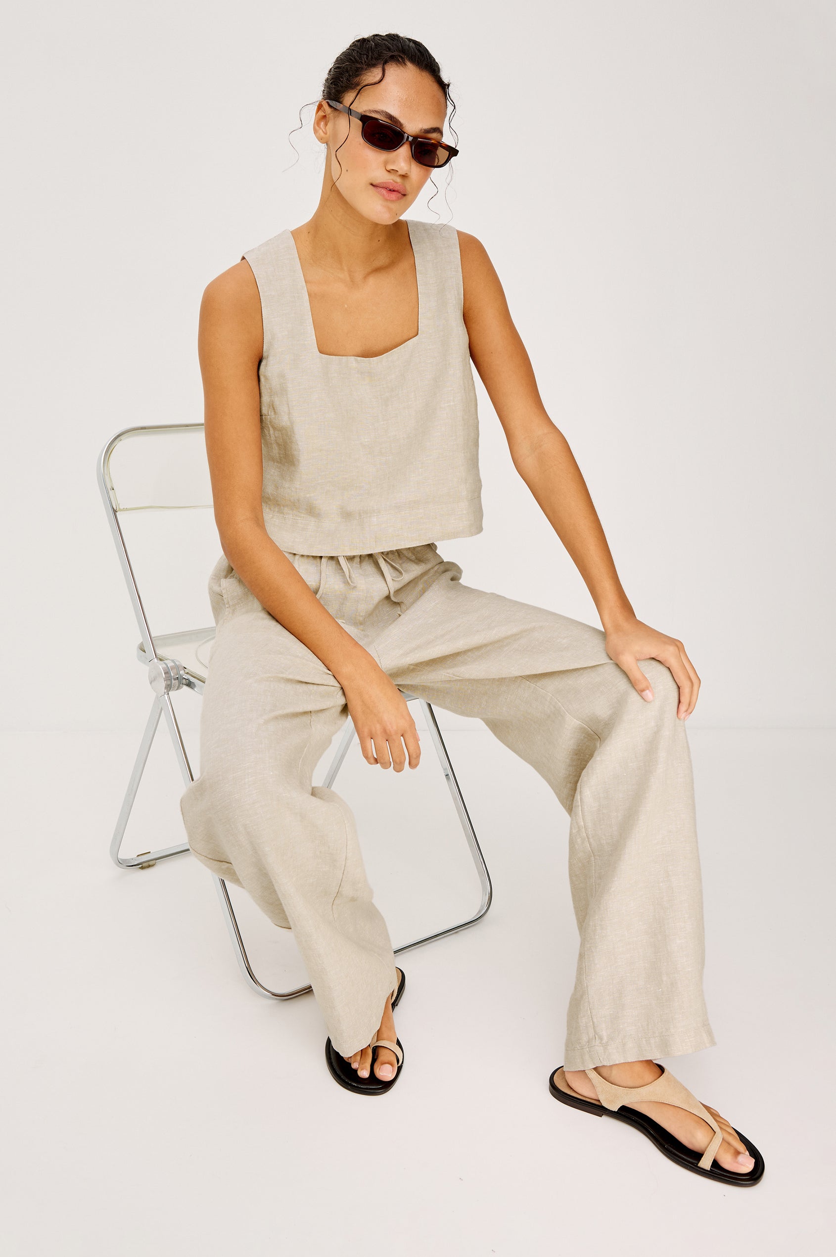 Emmie high rise linen wide leg pant with drawstring in Heathered Flax Colorway - Full Body Front View Shown on Model Sitting In Chair.