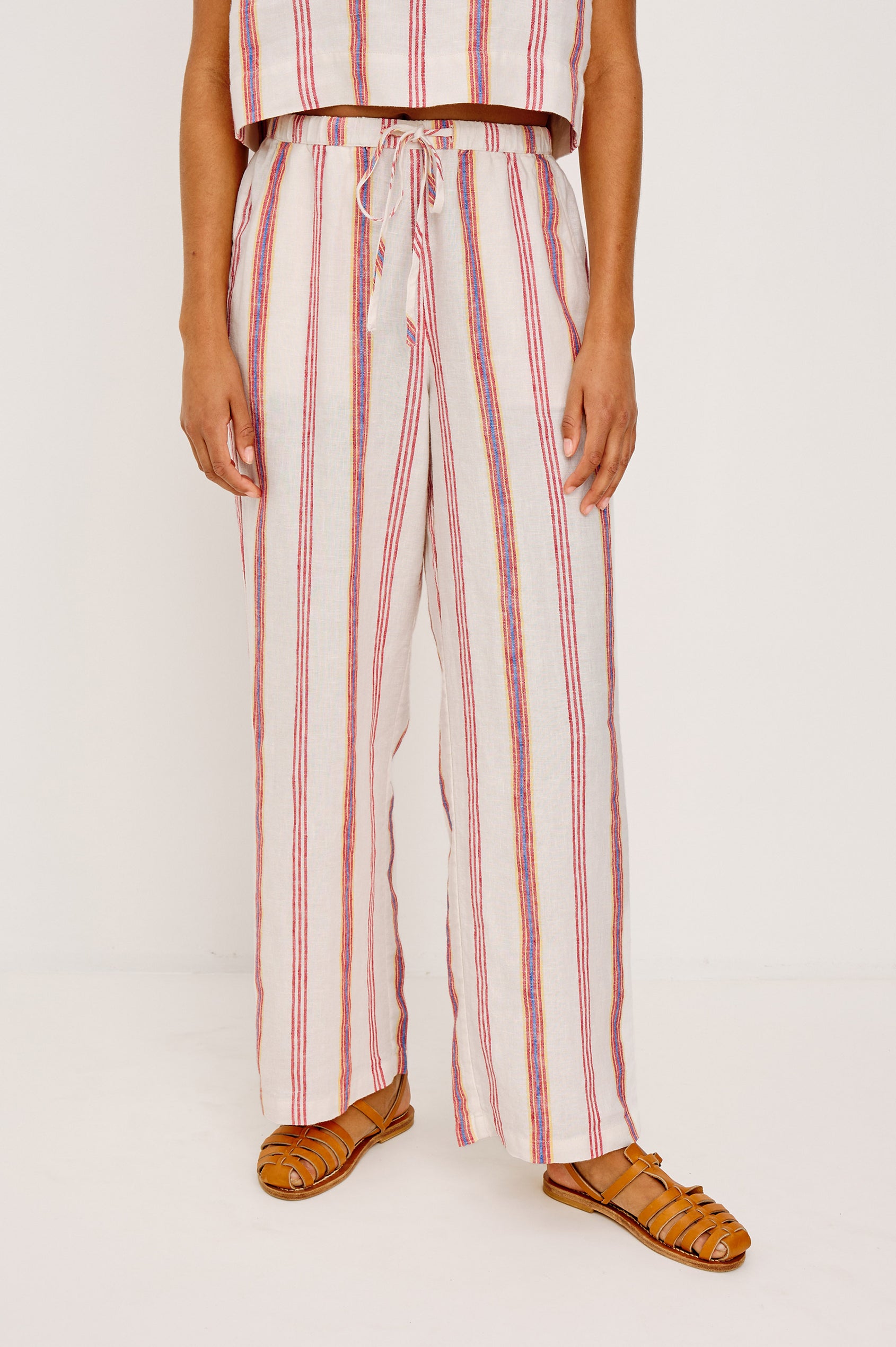Emmie Straight Leg Pant in Linen With Adjustable Drawstring Waist Ties and Side Pockets in Primavera Stripe Colorway — Lower Body Front View Featured on Model