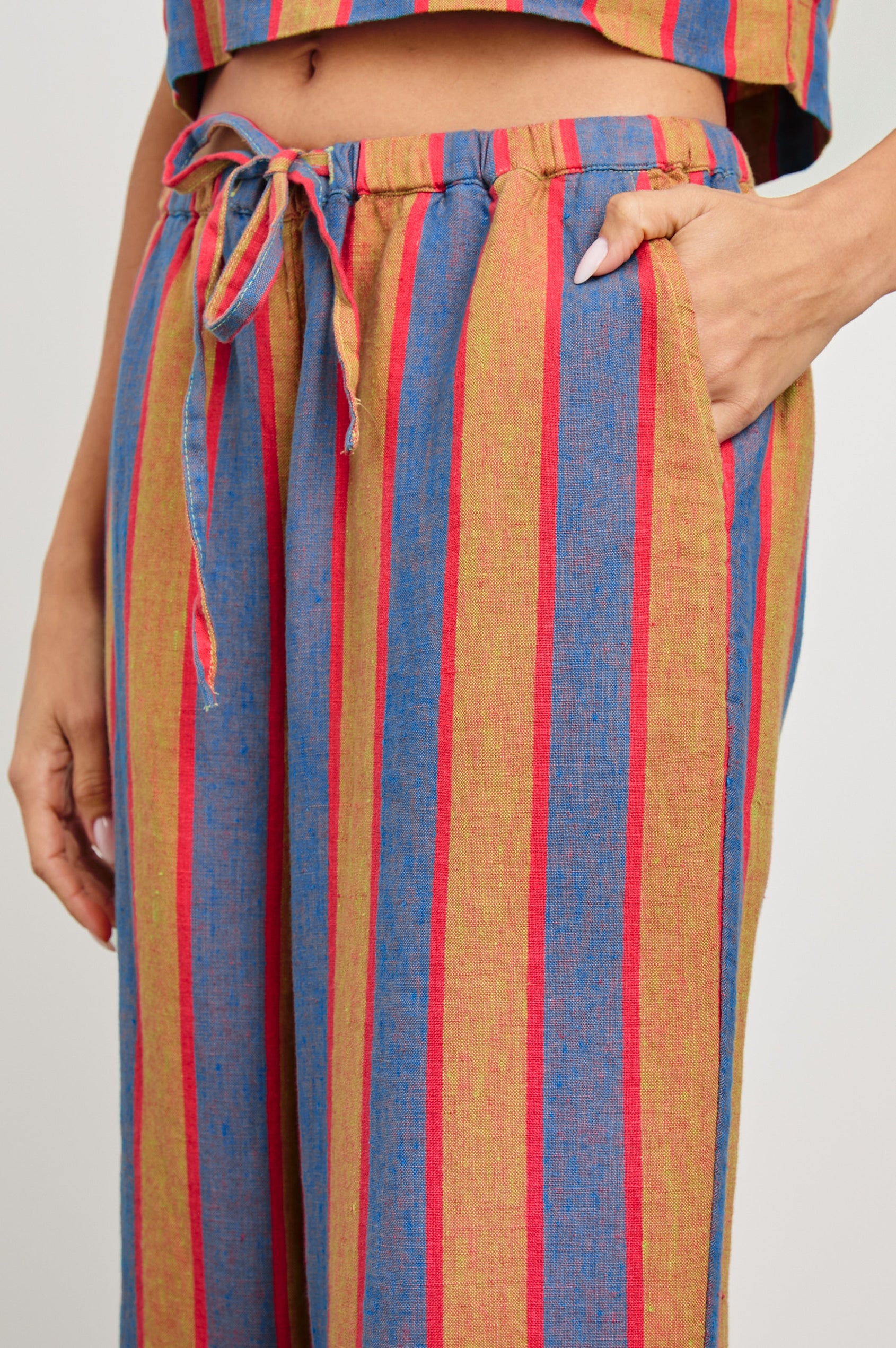 Emmie Pants with a Drawstring Waist and Two Front Pockets in Rio Stripe Colorway, Blue Tan and Pink Vertical Stripes - Side View Featured on Model