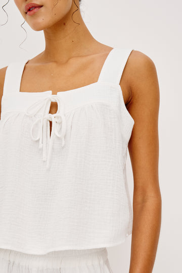 Enya Cropped Tank Top in Cotton Gauze With Square Neckline Wide Shoulder Straps Center Bust Keyhole With Adjustable Ties and Relaxed Fit in White Colorway - Upper Body Close Up View Featured on Model