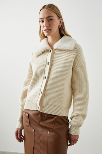 Esme Long-Sleeve Ribbed Sweater with Front Button Closure and a Faux Fur Collar in Ivory Colorway - Front View Featured on Model 