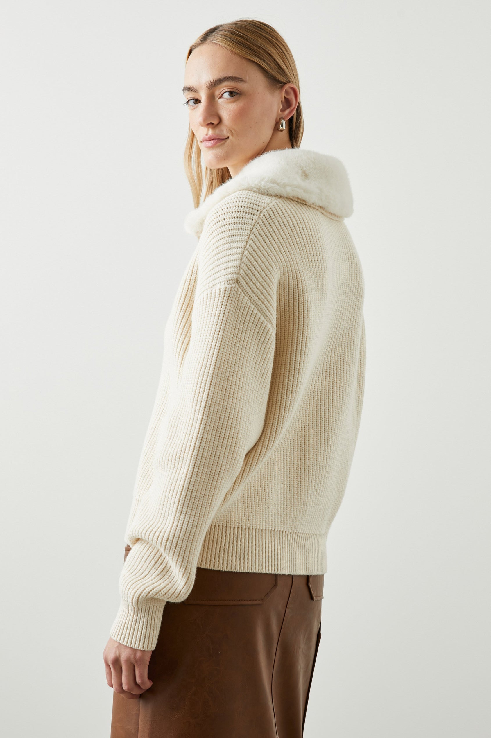 Esme Long-Sleeve Ribbed Sweater with Front Button Closure and a Faux Fur Collar in Ivory Colorway - Side View Featured on Model 