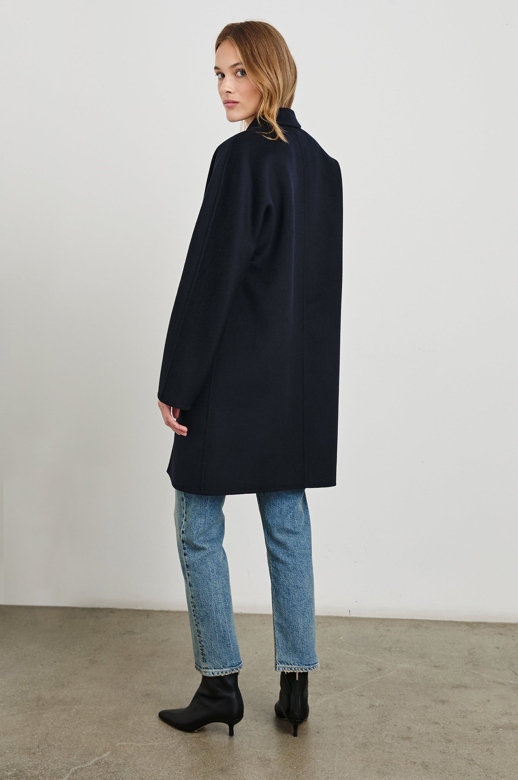 Everest Mid-Thigh Length Coat with Single Button Closure, Notched Lapels and Front Patch Pockets in Navy Colorway - Back Full Body View Featured on Model