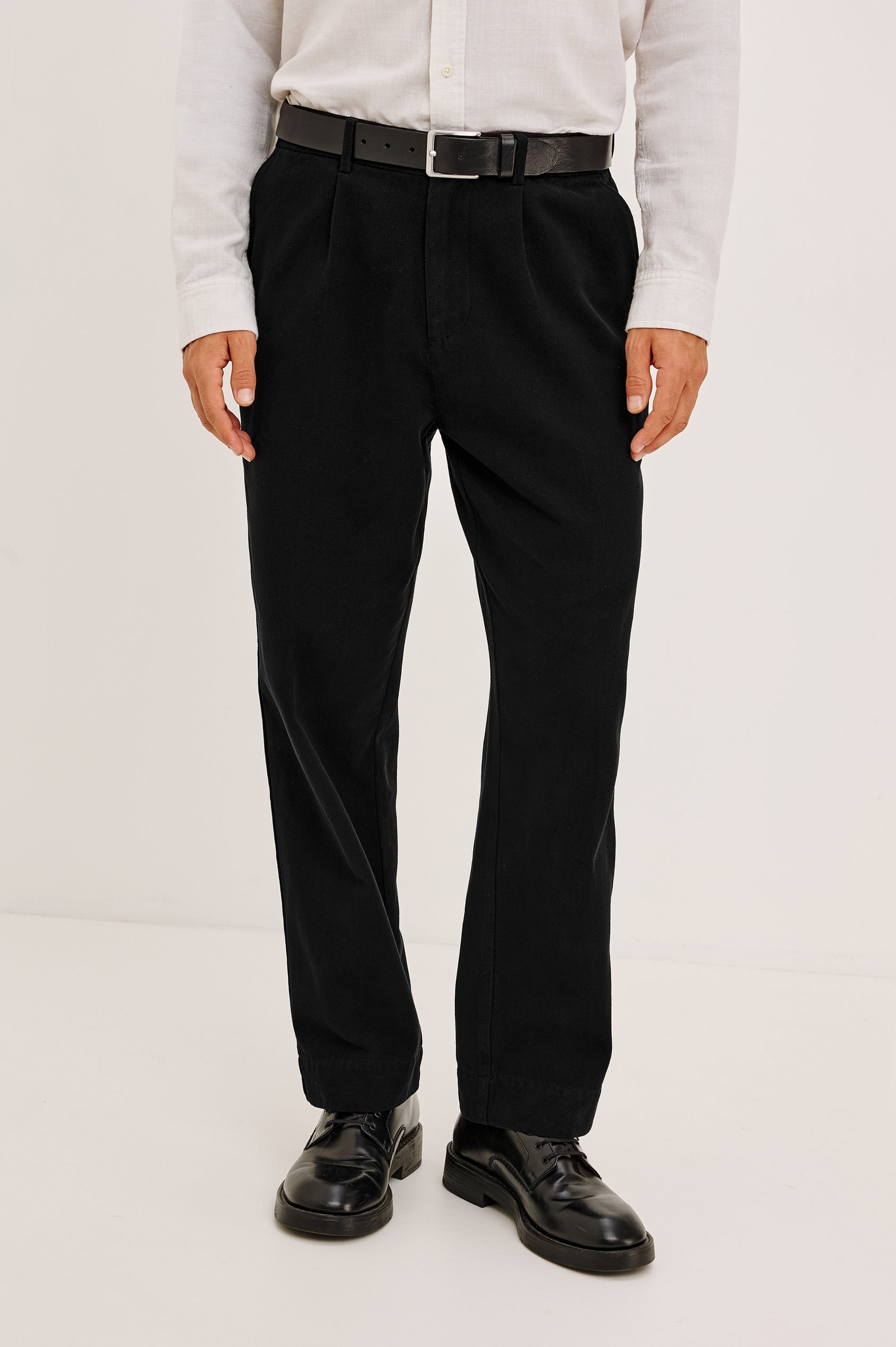 Ezra Pant in Brushed Cotton Twill With Relaxed Fit, Single Front Pleats, Ankle-Length Hem, Zip Fly, Side Pockets, and Back Double-Welt Pockets in Black Colorway - Full Body Front View Featured on Model