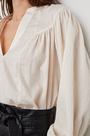 Fable Long Sleeve Top with a V Neck with a Placket, Buttoned Cuffs, and Pleating Down From the Yoke in Lotus Colorway - Front Tucked View Featured on Model 