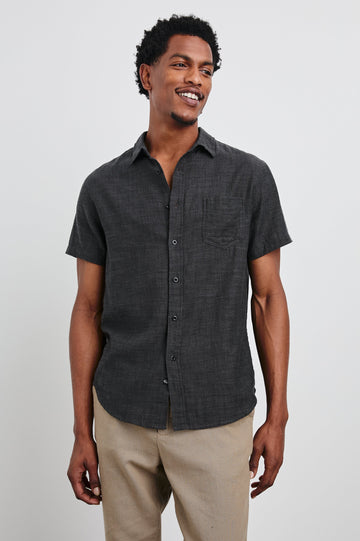 Fairfax Short-Sleeve Button Up with a Chest Patch Pocket in Black Chambray Colorway - Front View Featured on Model