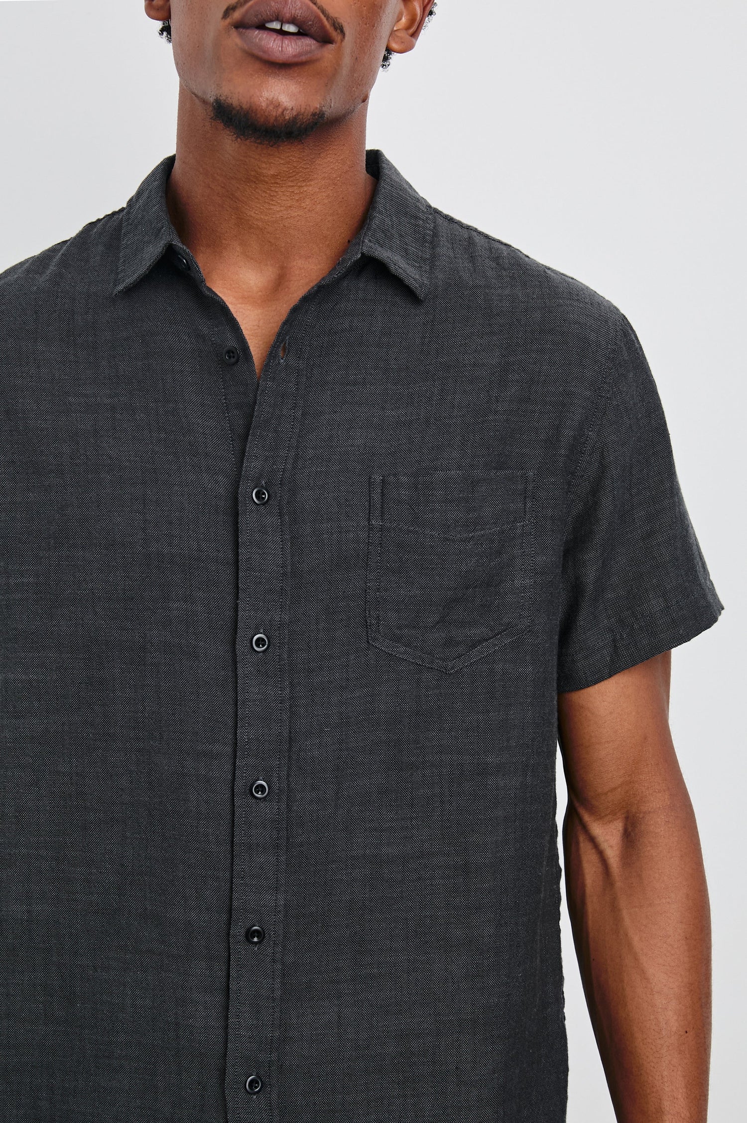 Fairfax Short-Sleeve Button Up with a Chest Patch Pocket in Black Chambray Colorway - Front View Featured on Model