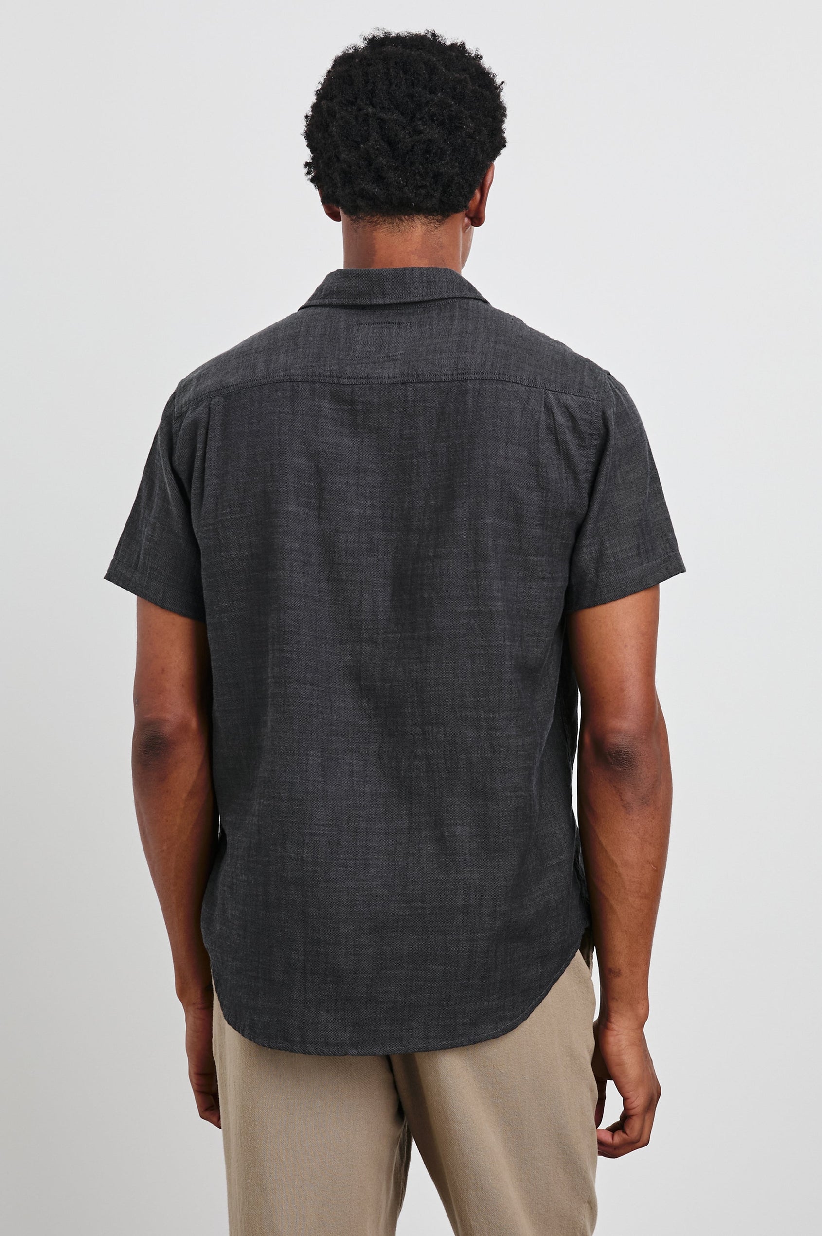Fairfax Short-Sleeve Button Up with a Chest Patch Pocket in Black Chambray Colorway - Back View Featured on Model