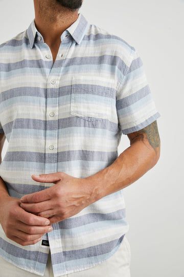 Fairfax Short-Sleeve Button Up with a Chest Patch Pocket in Tabernas Shadow Colorway, with light grey, dark grey, blue and white horizontal stripes - Front View Featured on Model