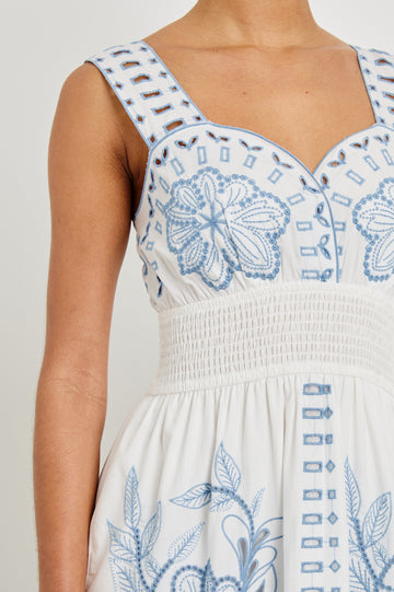 Zoomed in detail shot of model wearing our sleeveless, Fawn Midi Dress in White with Blue Embroidery contrast and eyelet details. 