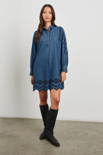 Fernanda Long-Sleeve Mini Dress with Button Cuffs, a Collar, a Placket with Buttons, a Scalloped Hem, a Floral Eyelet Design on the Sleeves and a Floral and Geometric Eyelet Design on the Hem in Dark Vintage Wash Colorway - Front Full Body View Featured on Model