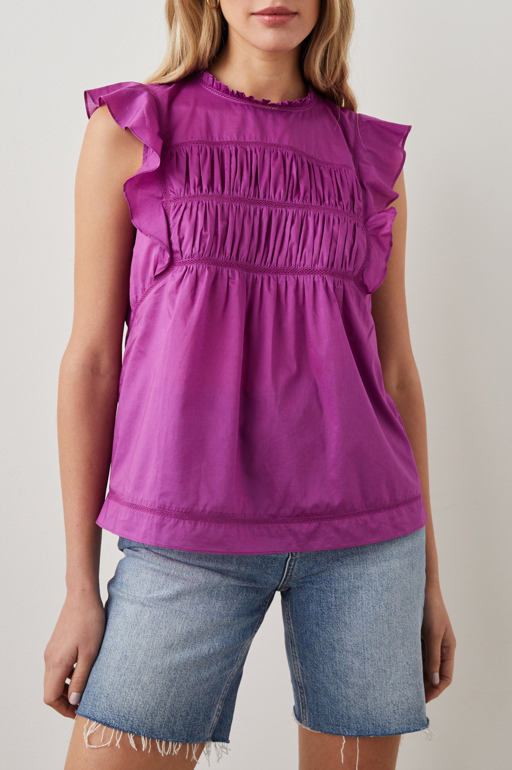 Filomena Short Sleeve Top with Flutter Sleeves, a Ruffled Neck, a Shirred Center Bodice, Lace Inserts and a Buttoned Keyhole at the Back in Berry Colorway - Front View Featured on Model