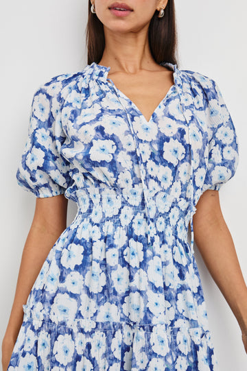 Fiorella Short-Sleeve, Above-Knee Dress with a Shirred Collar and Waist, V-neckline with Ties, Puff Sleeves and a Tiered Skirt in Blue Floral Colorway, Blues and White - Front View Featured on Model