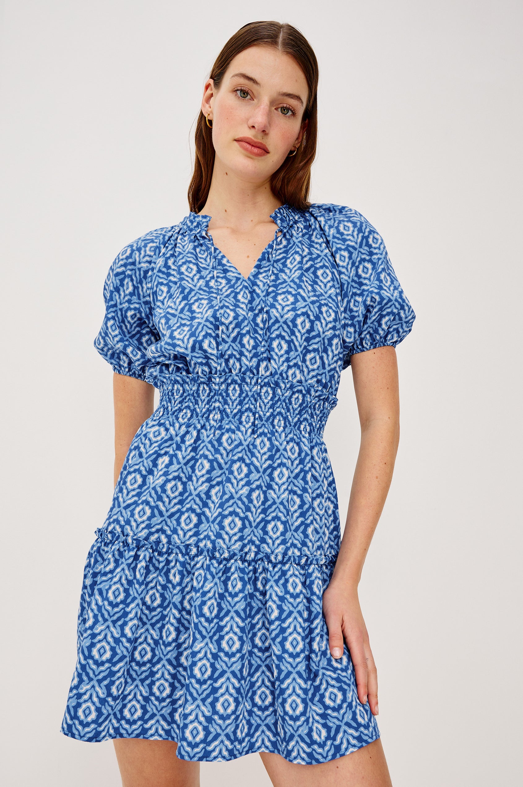 Fiorella Mini Dress in Crinkle Chiffon With Split V-Neck and Adjustable Ties Short Puff Sleeves Shirred Waist and Lined Tiered Skirt in Blue Ikat Colorway - Upper Body Front View Featured on Model