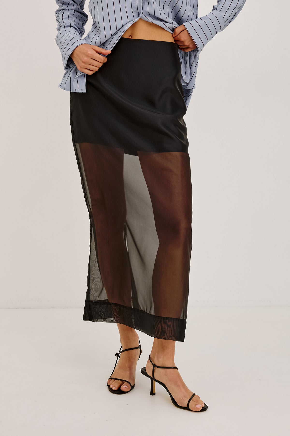 Floran Midi Skirt in Sheer Organza With Mini Lining, Side Zip, Straight Hem, and Back Slit in Black Organza Colorway - Front View Featured on Model.