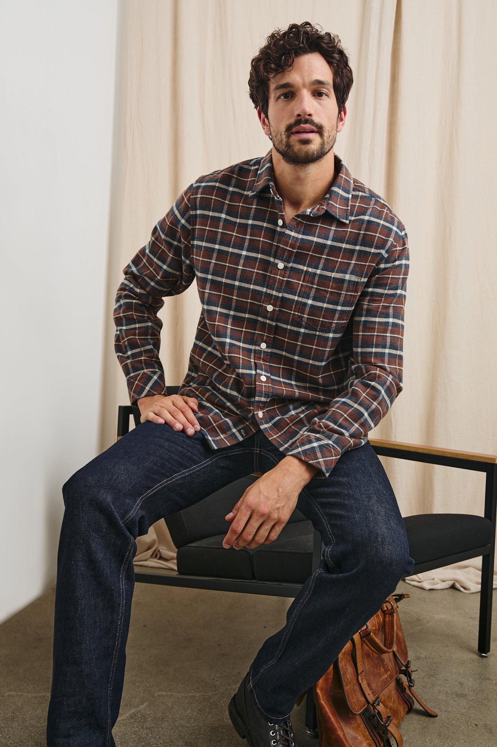 Forrest Long-Sleeve Button Up with a Chest Patch Pocket in Hickory Blue Melange Colorway, a Brown, Blue and White plaid - Front View Full Body Featured on Seated Model
