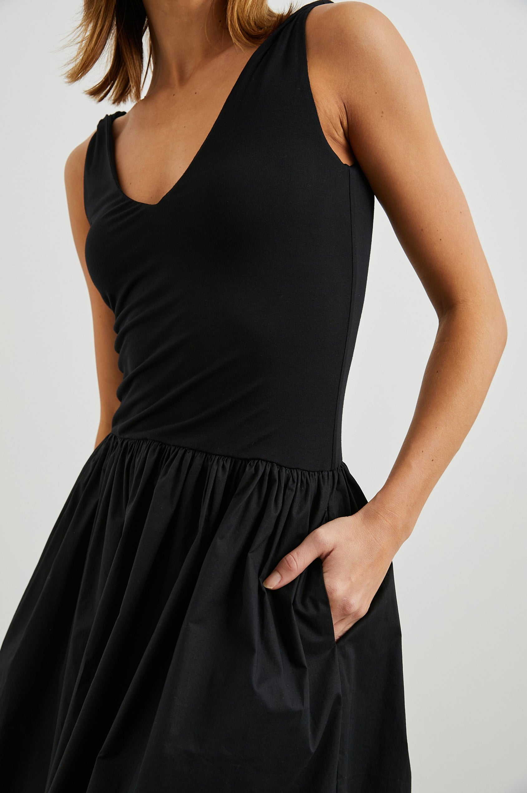 Franca Sleeveless Midi Dress with Twisted Shoulder Straps, a deep V Neck and Pleats at the Waist in Black Colorway - Front View Featured on Model