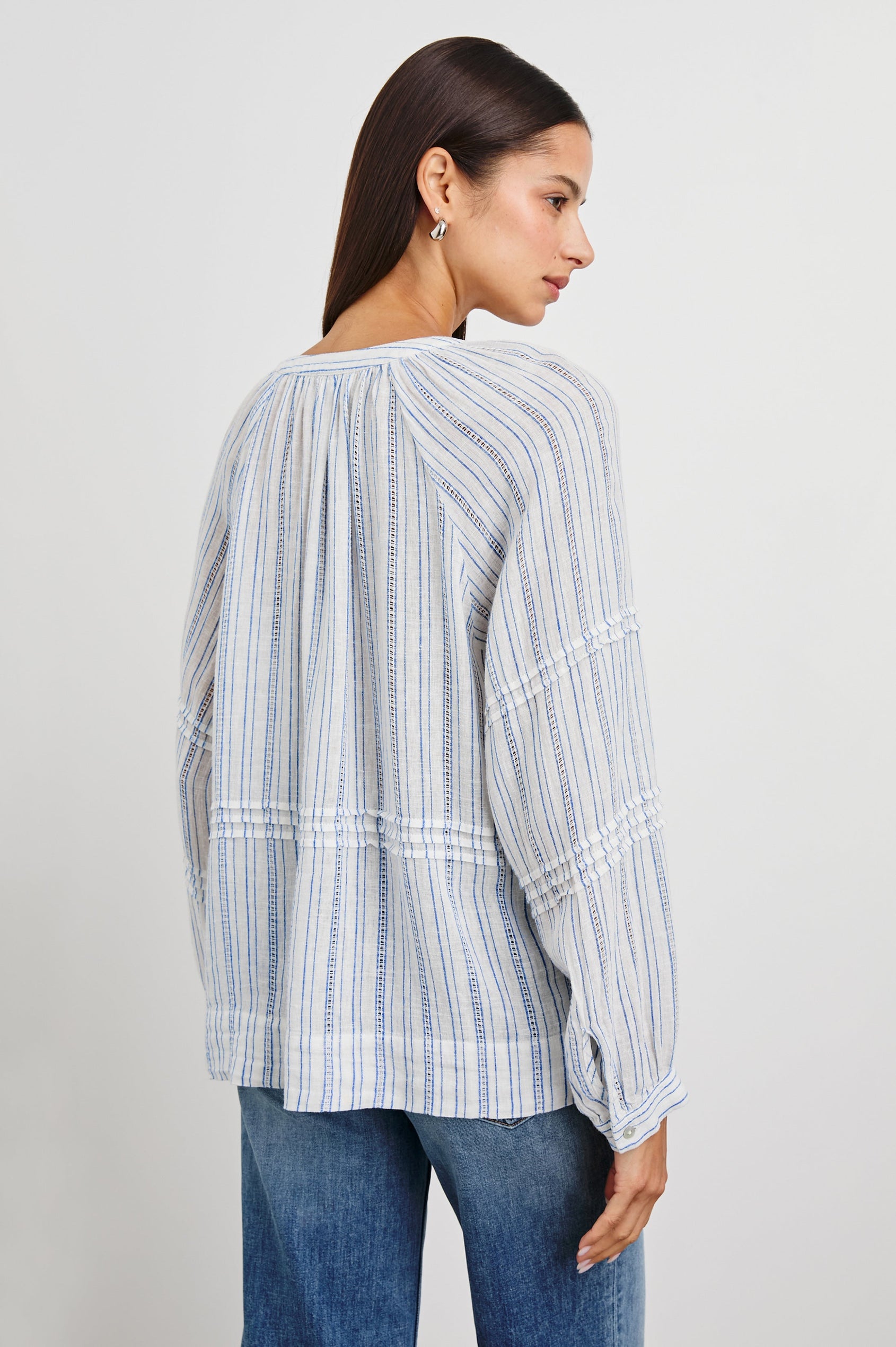 Frances Long-Sleeve Top with Buttons Down the Front, Button Cuffs, and Pleating Around the Neckline in Sonoma Stripe Colorway, Thin Blue Vertical Stripes on White - Back View Featured on Model