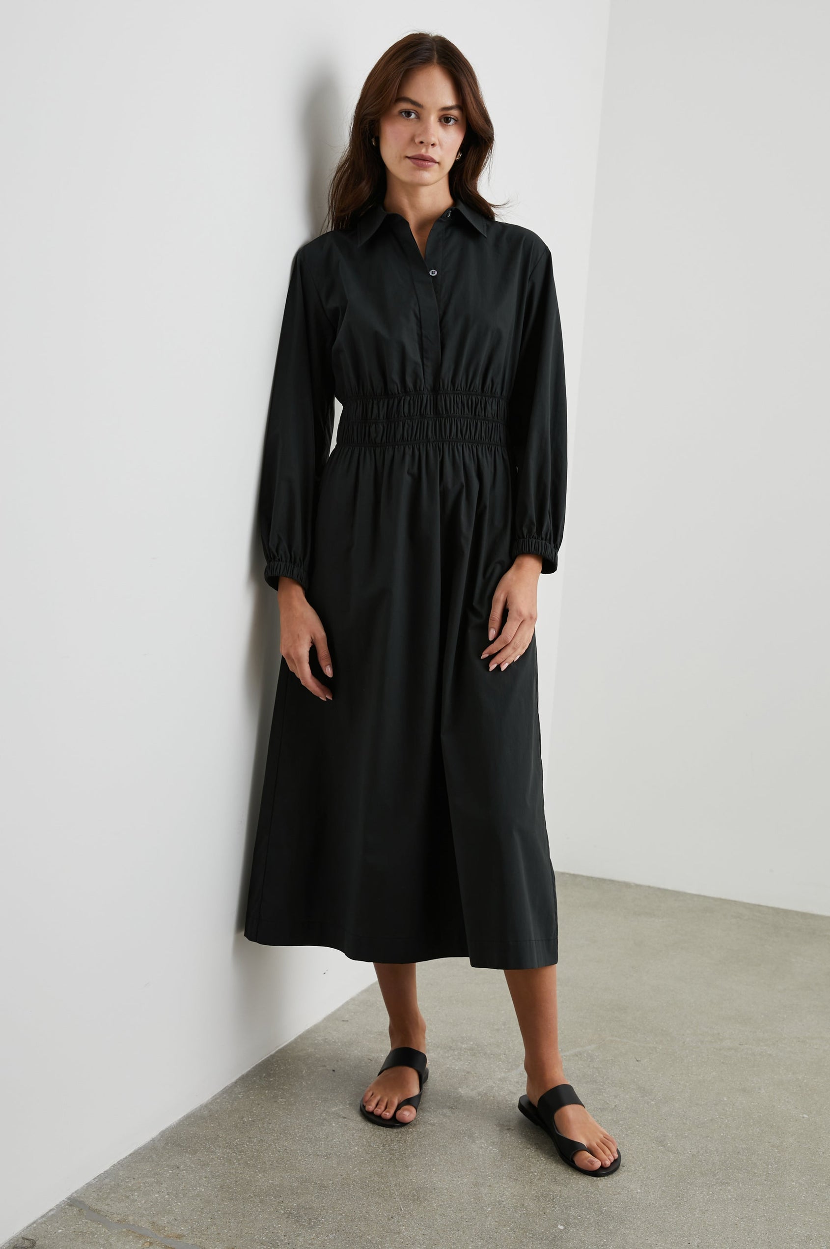 Fraya Long-Sleeve Midi Dress with a Concealed Button Placket on the Bodice, a Collar, a Shirred Waist, and Two Hip Pockets in Black Colorway - Front Full Body View Featured on Model 