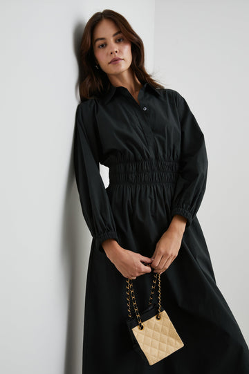 Fraya Long-Sleeve Midi Dress with a Concealed Button Placket on the Bodice, a Collar, a Shirred Waist, and Two Hip Pockets in Black Colorway - Front View Featured on Model 