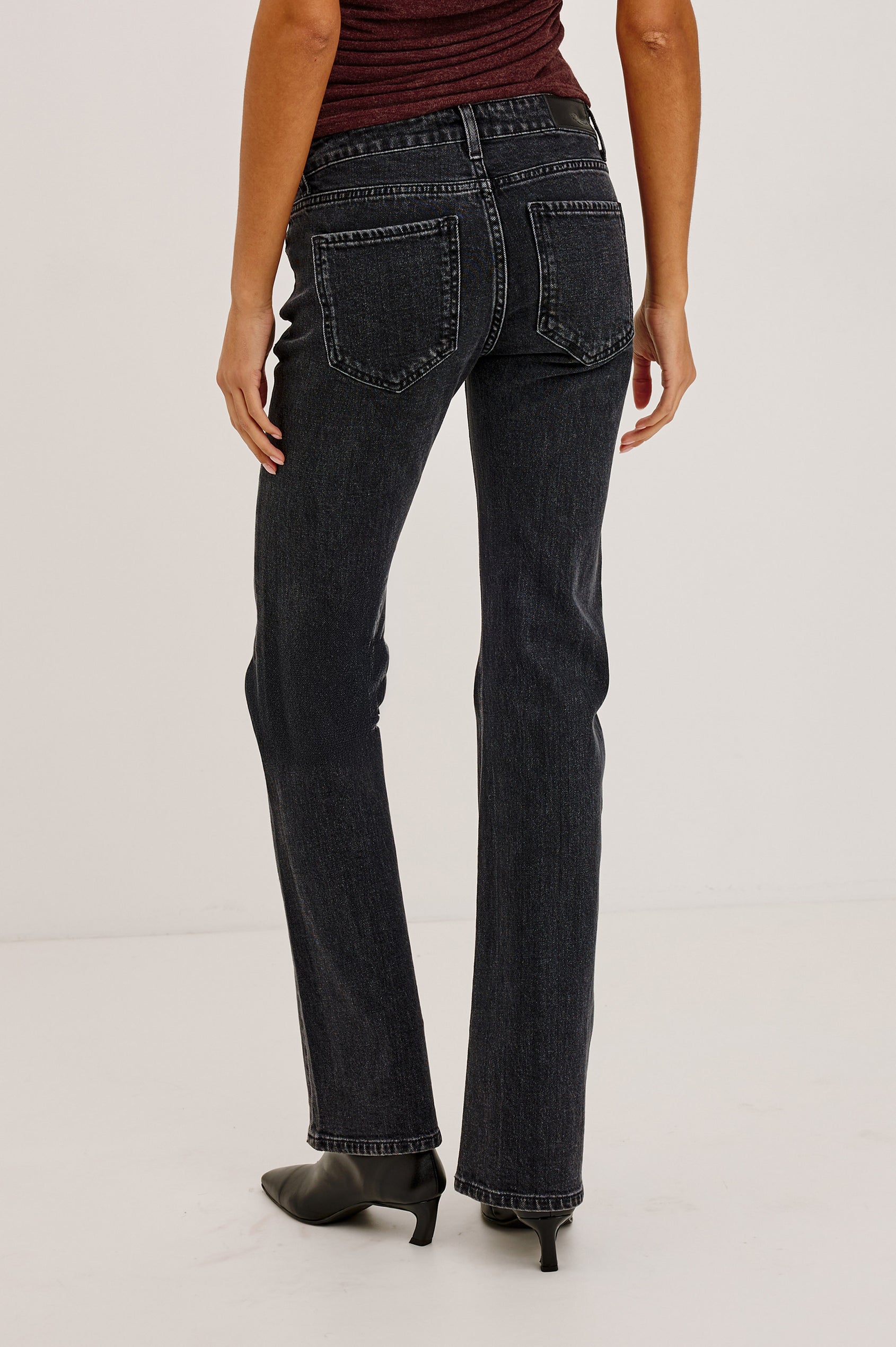 Fremont Petite Low Rise Bootcut Jean in Light Stretch Denim With Extended Inseam, 5-Pockets, Distressed Details, Belt Loops, and Zip-Fly Closure in Blackjack Colorway - Lower Body Back View Featured on Model