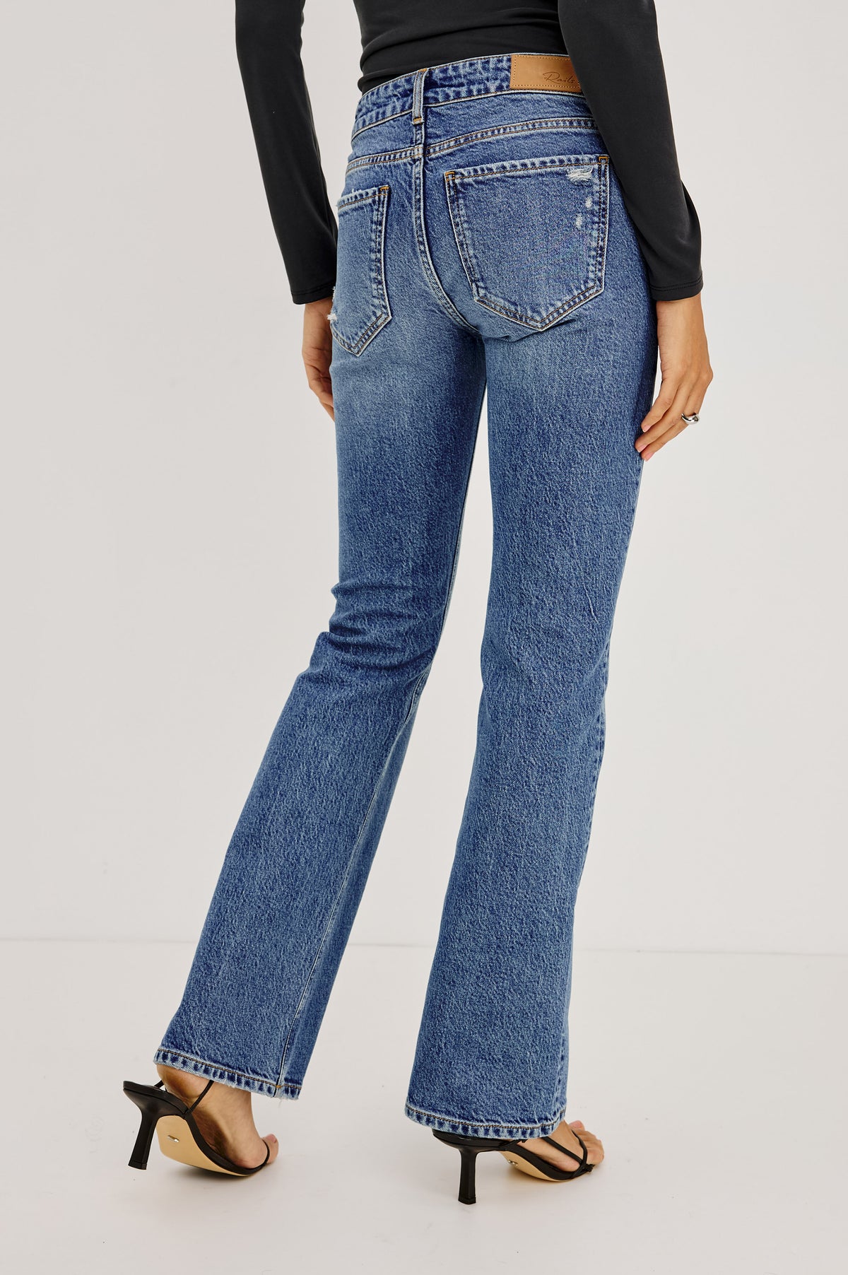 Fremont Low Rise Bootcut Jean in Light Stretch Denim With Extended Inseam, 5-Pockets, Distressed Details, Belt Loops, and Zip-Fly Closure in Pioneertown Colorway - Lower Body Back View Featured on Model